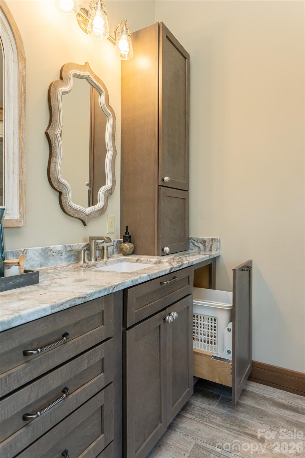 Custom pull-out hamper drawers on each side of the vanity add convenience and functionality to the primary bath. - 660 Pleasant Grove Road, Hendersonville