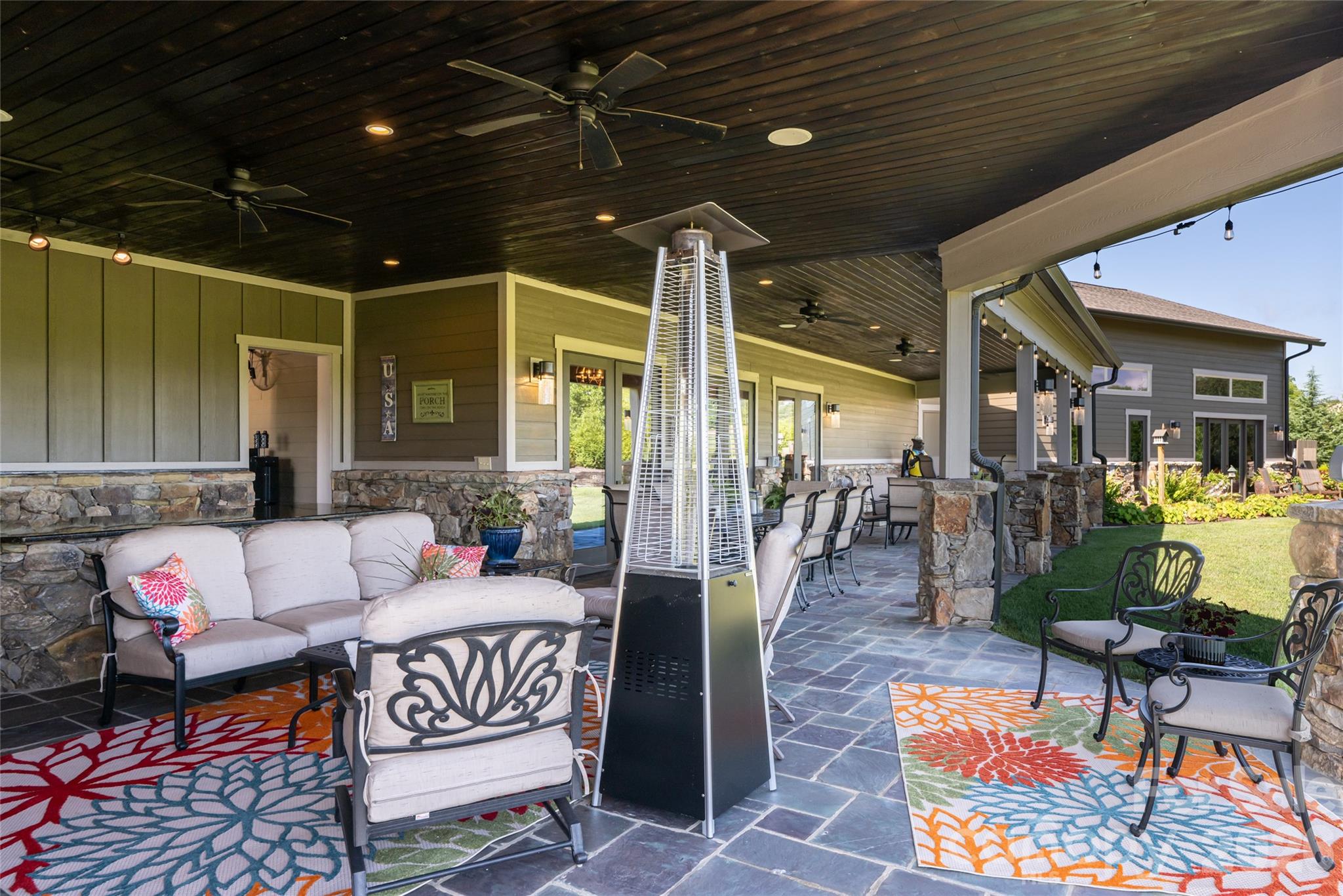 Covered patio currently arranged for dining accommodations for 18, in addition to a separate sitting area. - 660 Pleasant Grove Road, Hendersonville