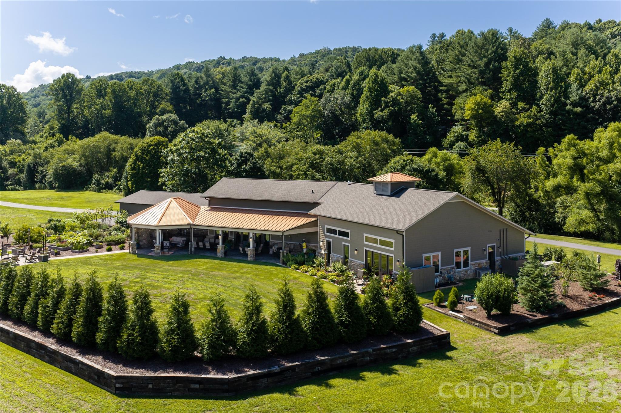 Beautifully landscaped rear exterior showcasing the home’s private backyard setting. - 660 Pleasant Grove Road, Hendersonville