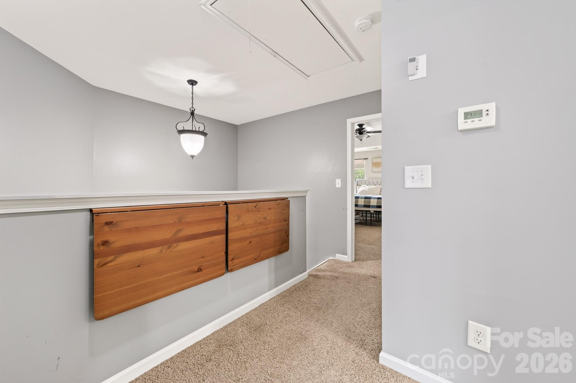 Upstairs hall with mounted table outside laundry - 8261 Bridgegate Drive, Huntersville