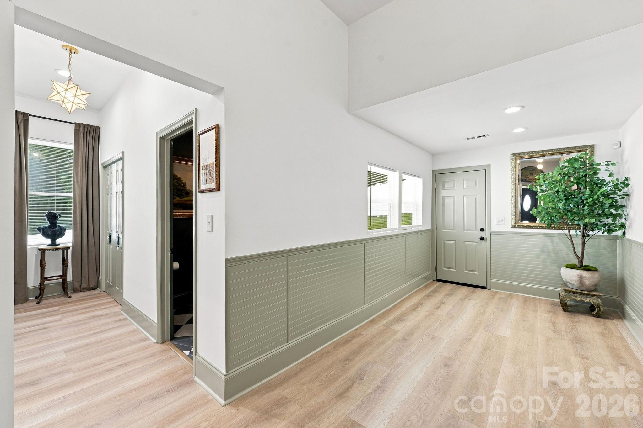 Rear hallway with beadboard paneling and access to the laundry room and 1/2 bath - 527 S 2nd Street, Albemarle