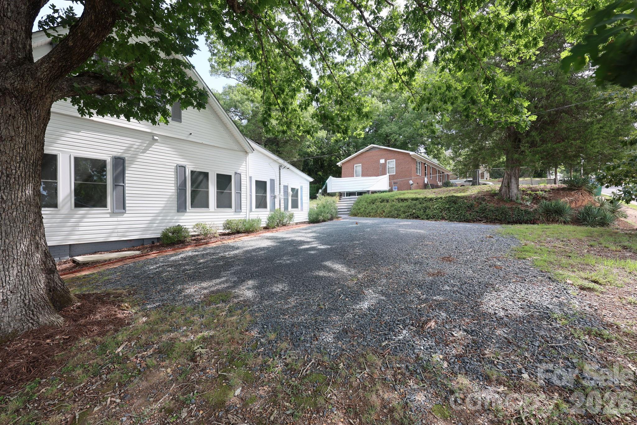 Gravel driveway for parking, plus a carport inside the fenced yard - 527 S 2nd Street, Albemarle