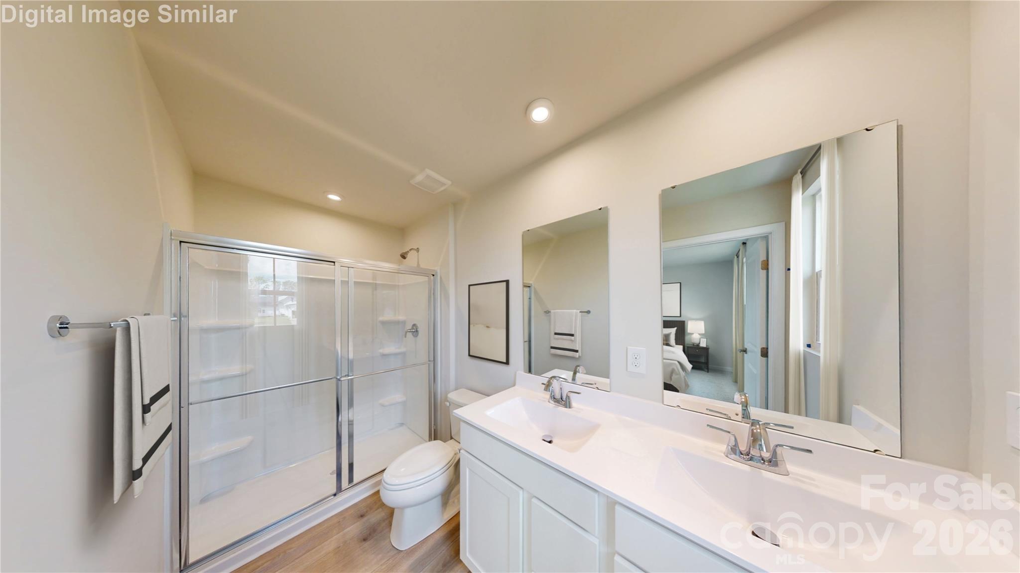 Steam, style, and space! This luxurious primary bath features a spa-worthy shower and dual vanities — perfect for mornings that start with calm and end with glam! - 1208 Elm Forest Lane, China Grove
