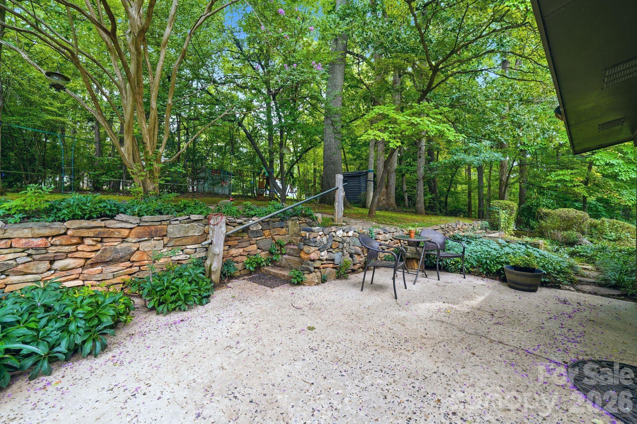 Secret Garden backyard with stone walls, pathways leading to a level, private backyard - 515 Dogwood Lane, Belmont