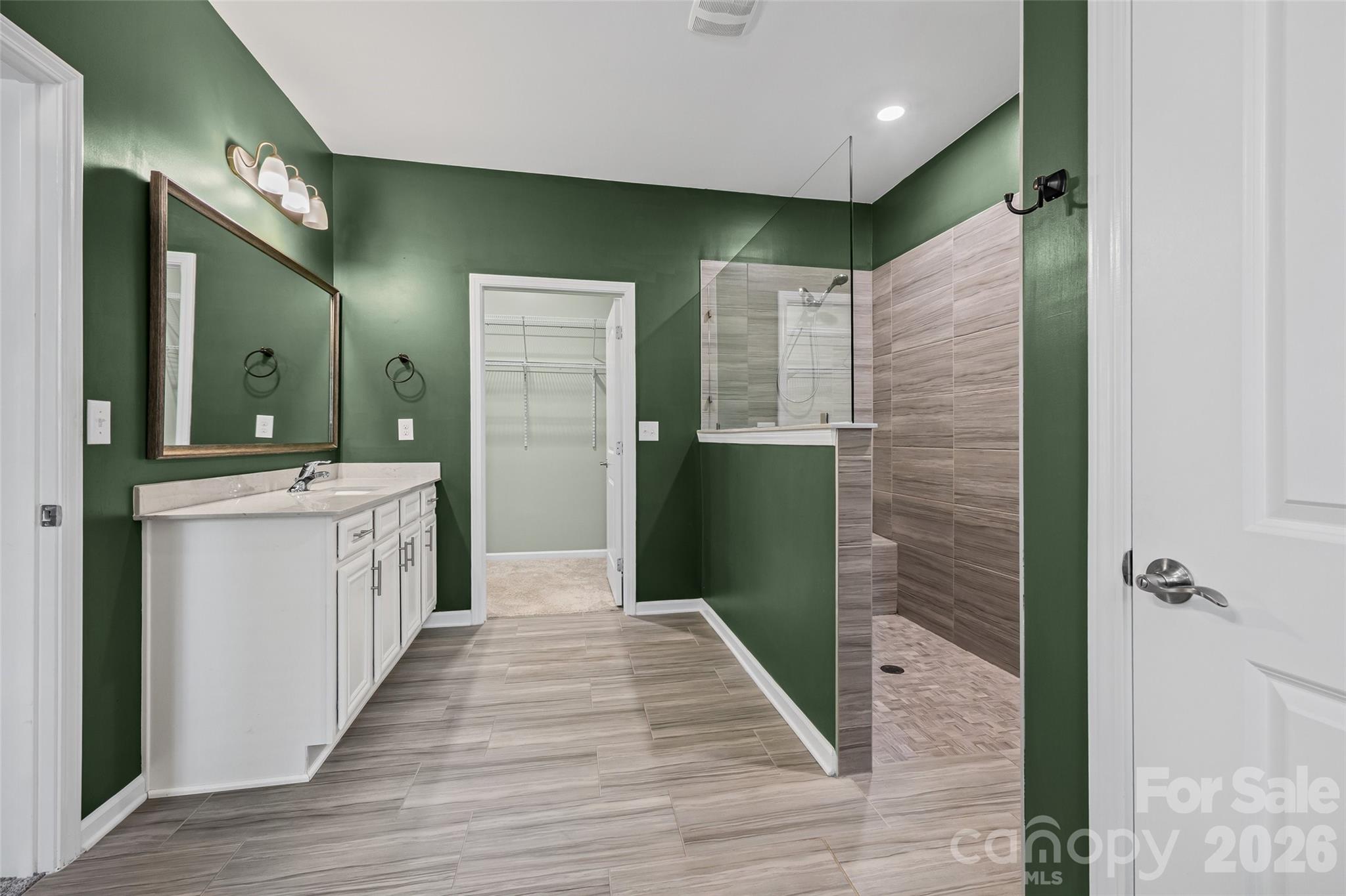 Spa-like primary ensuite featuring dual vanities and an oversized zero-entry walk-in shower—perfect for relaxing and unwinding at the end of the day. - 596 Rustlewood Way, Rock Hill