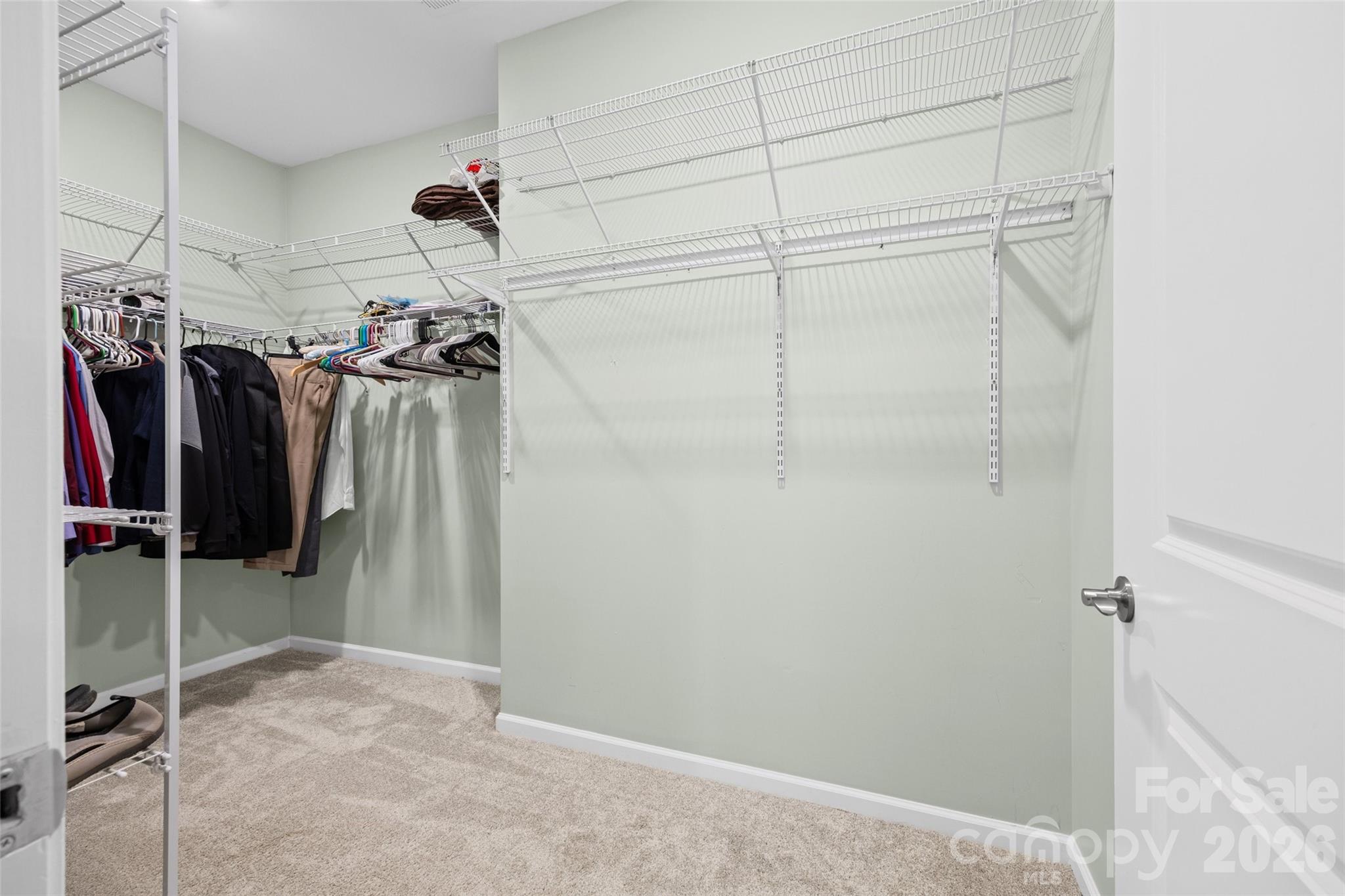 Generously sized primary closet offers plenty of room to organize wardrobes by season, with space for everything in its place. - 596 Rustlewood Way, Rock Hill