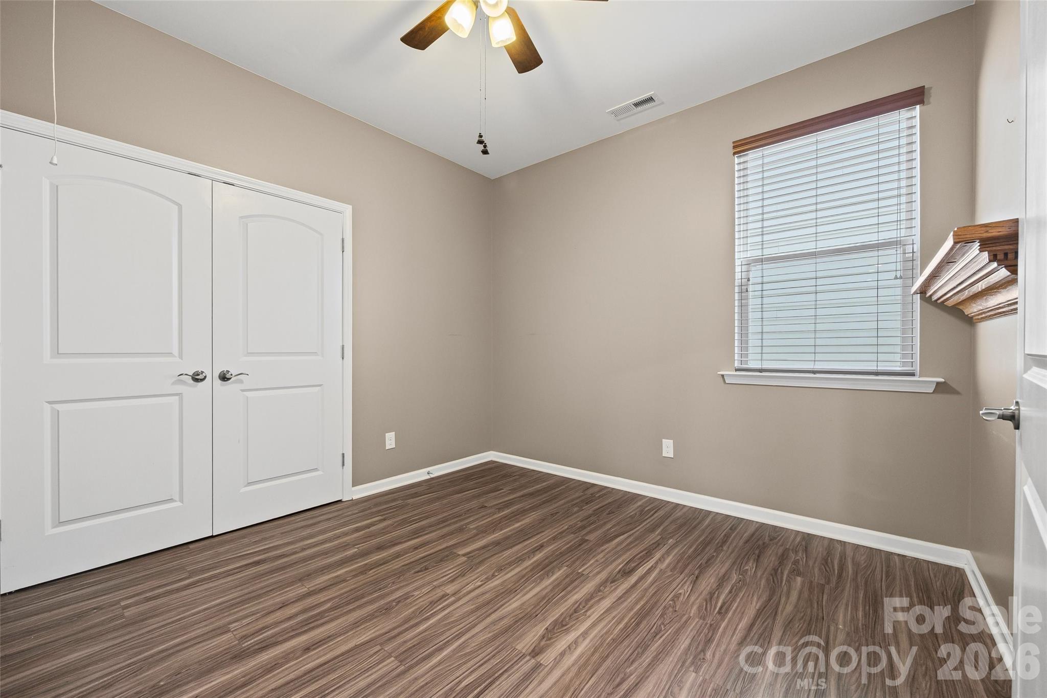 Versatile bedroom with ceiling fan and generous closet space—perfect for a bedroom, guest room, or comfortable home office. - 596 Rustlewood Way, Rock Hill