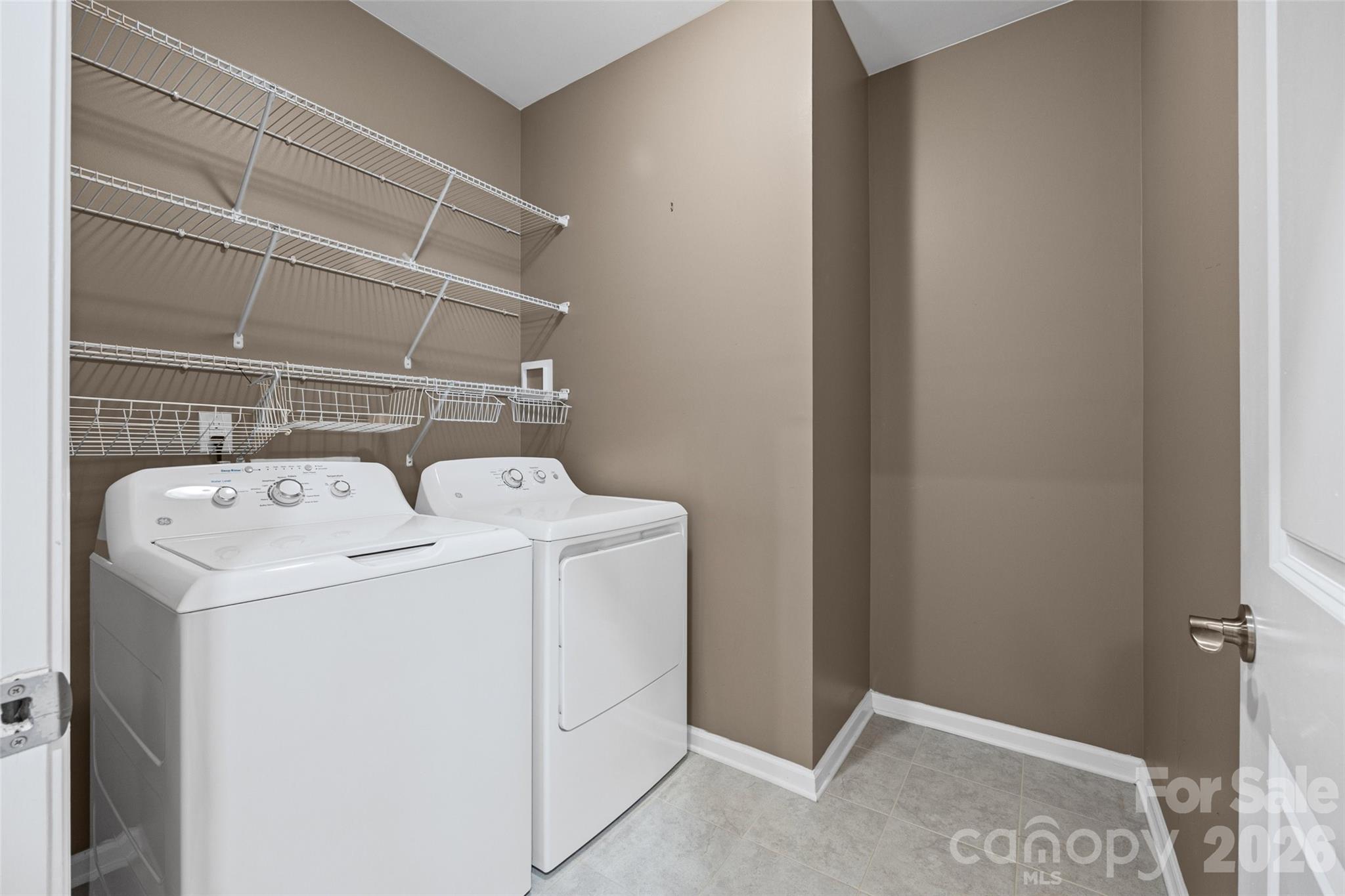 Convenient laundry room with washer and dryer, generous space to move comfortably, and a door to keep everyday laundry out of sight when needed. - 596 Rustlewood Way, Rock Hill