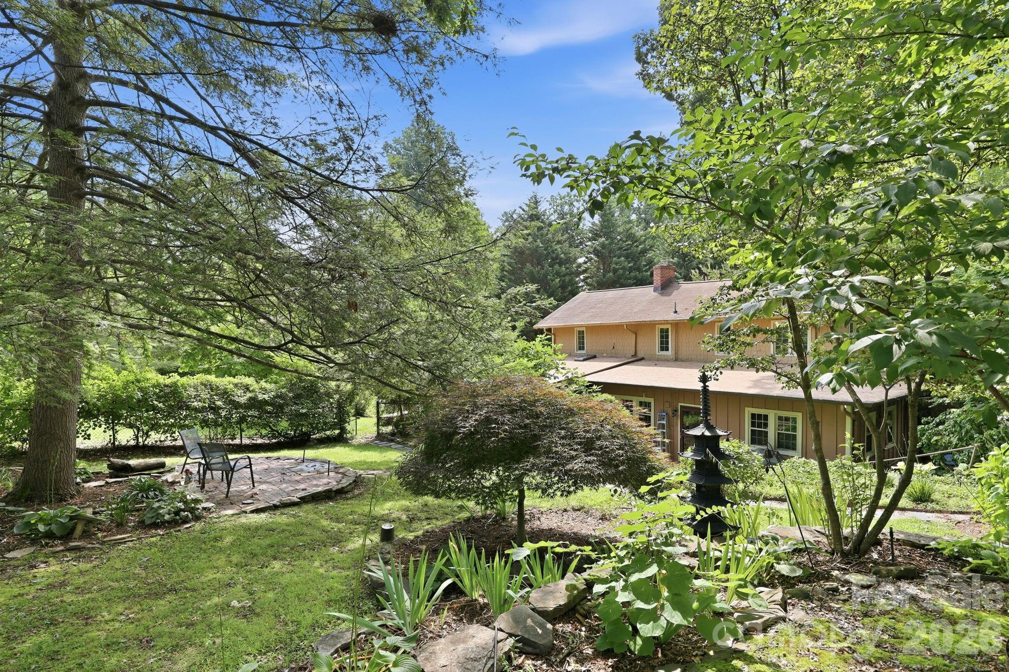 The manicured landscaping abounds on the property. Wonderful shaded patio area - 1925 Laurel Park Highway, Hendersonville