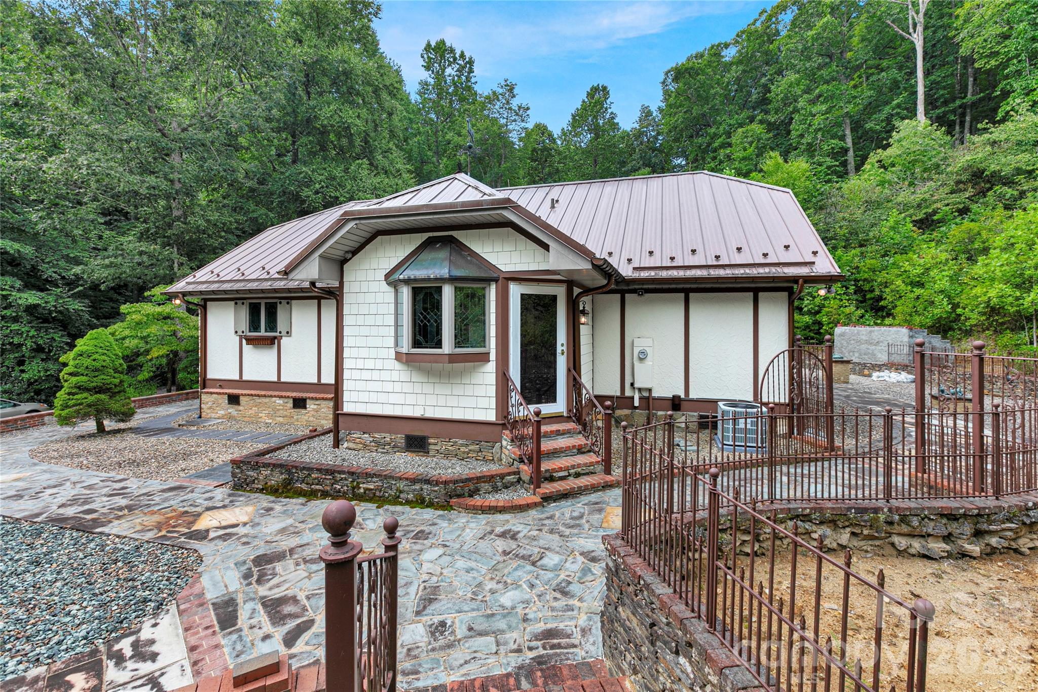 Lady Bug Garden side of the house with its iron fences, stone walls and pathways! This door leads to the bonus room! Small family guest bedroom? Sitting reading meditation room? So many possibilities for it! - 275 Hubbard Hollow Road, Rosman