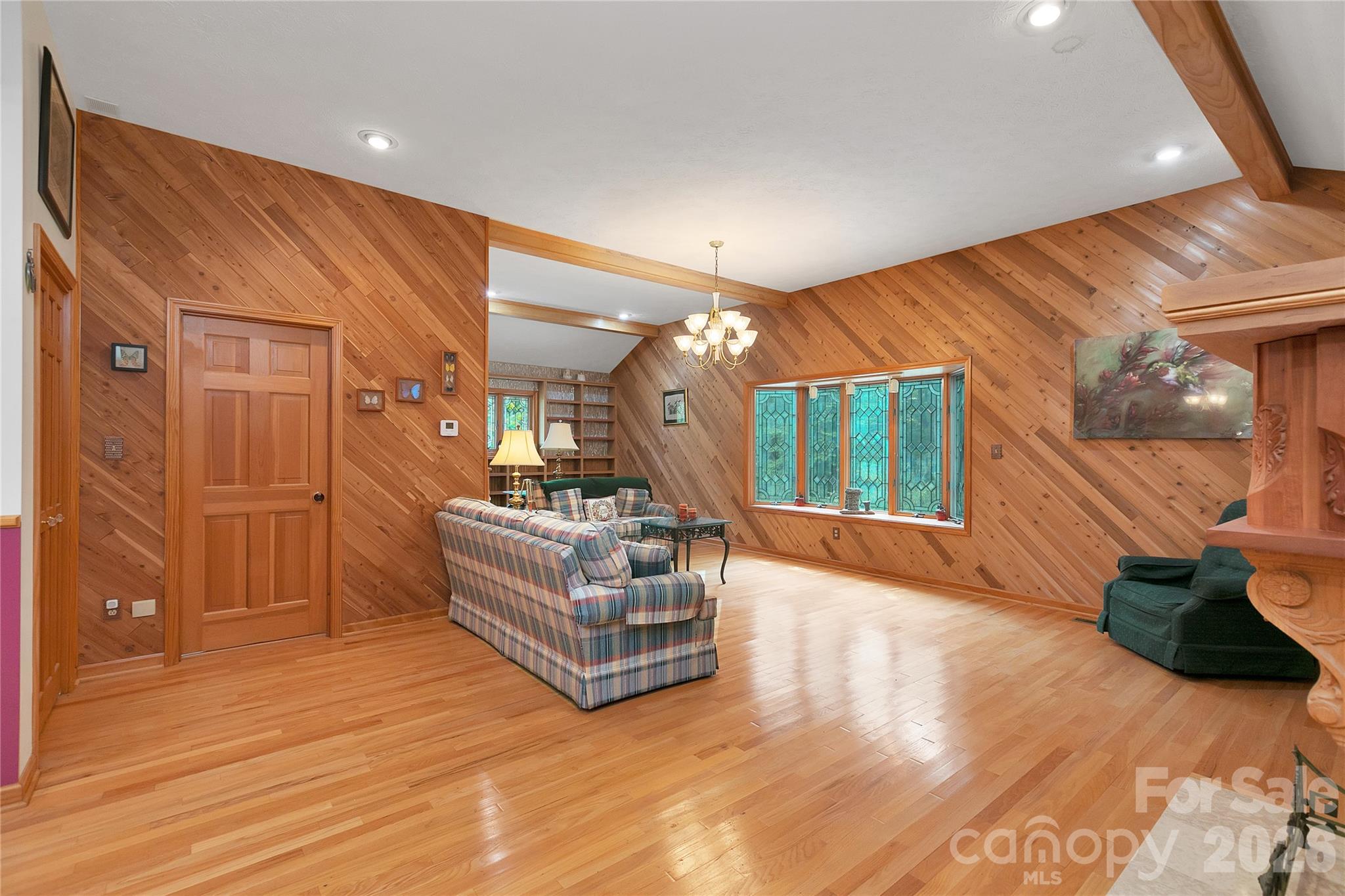 The living room is quite spacious and well appointed. Every window and door in the entire house is adorned with stained glass! Beautiful hardwood floors! - 275 Hubbard Hollow Road, Rosman