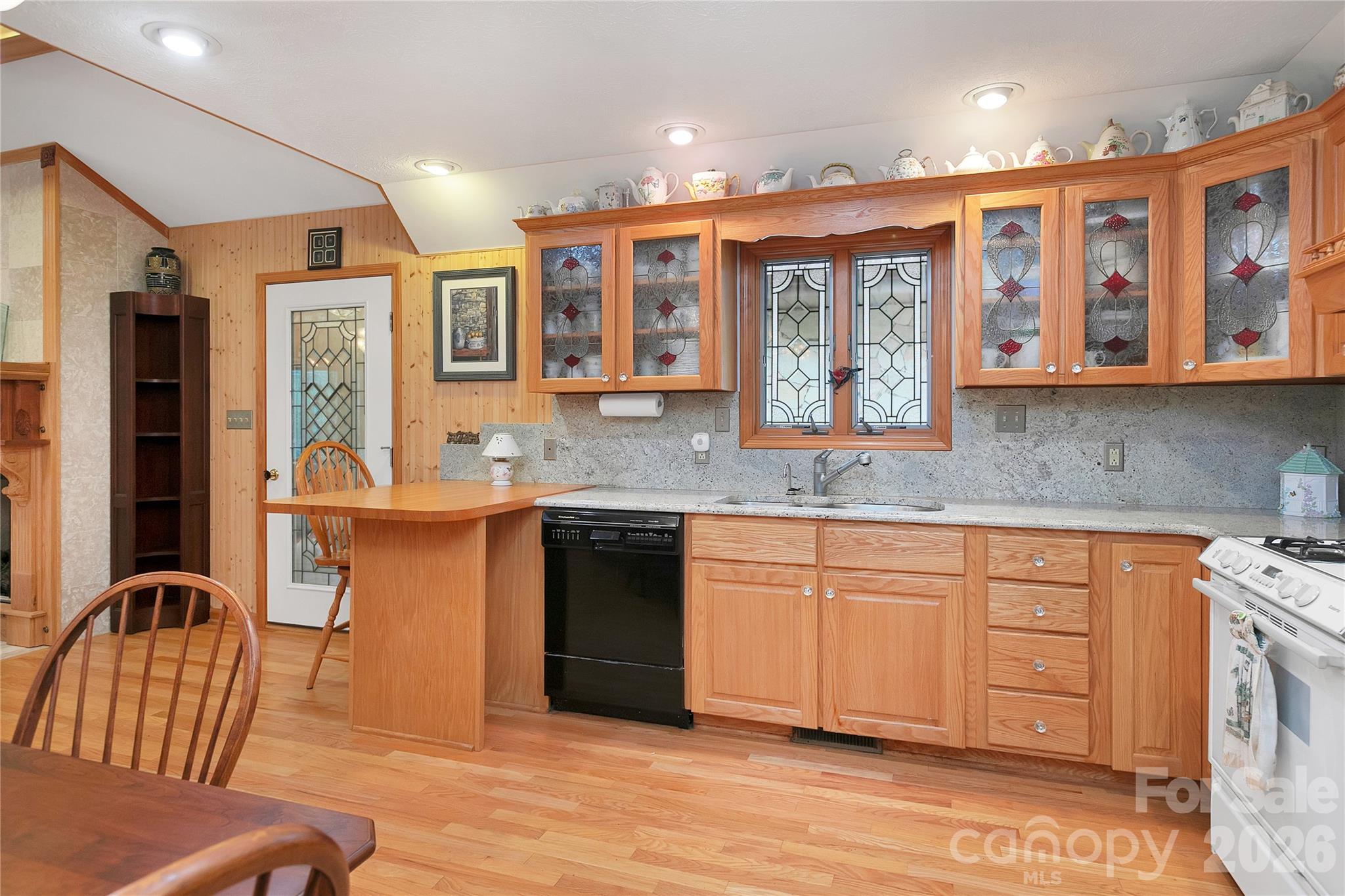 The kitchen is equipped with a full complement of appliances. Lots of elegant cabinets with stained glass fronts, and the stained-glass window over the sink looking out to the back area.! - 275 Hubbard Hollow Road, Rosman