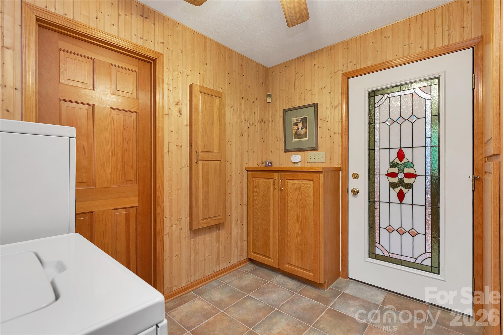 Just off of the primary bedroom is the laundry room and the primary bathroom, separate rooms! The washer / dryer set convey. The stained-glass door leads to the bonus room overlooking Lady Bugs Garden! - 275 Hubbard Hollow Road, Rosman