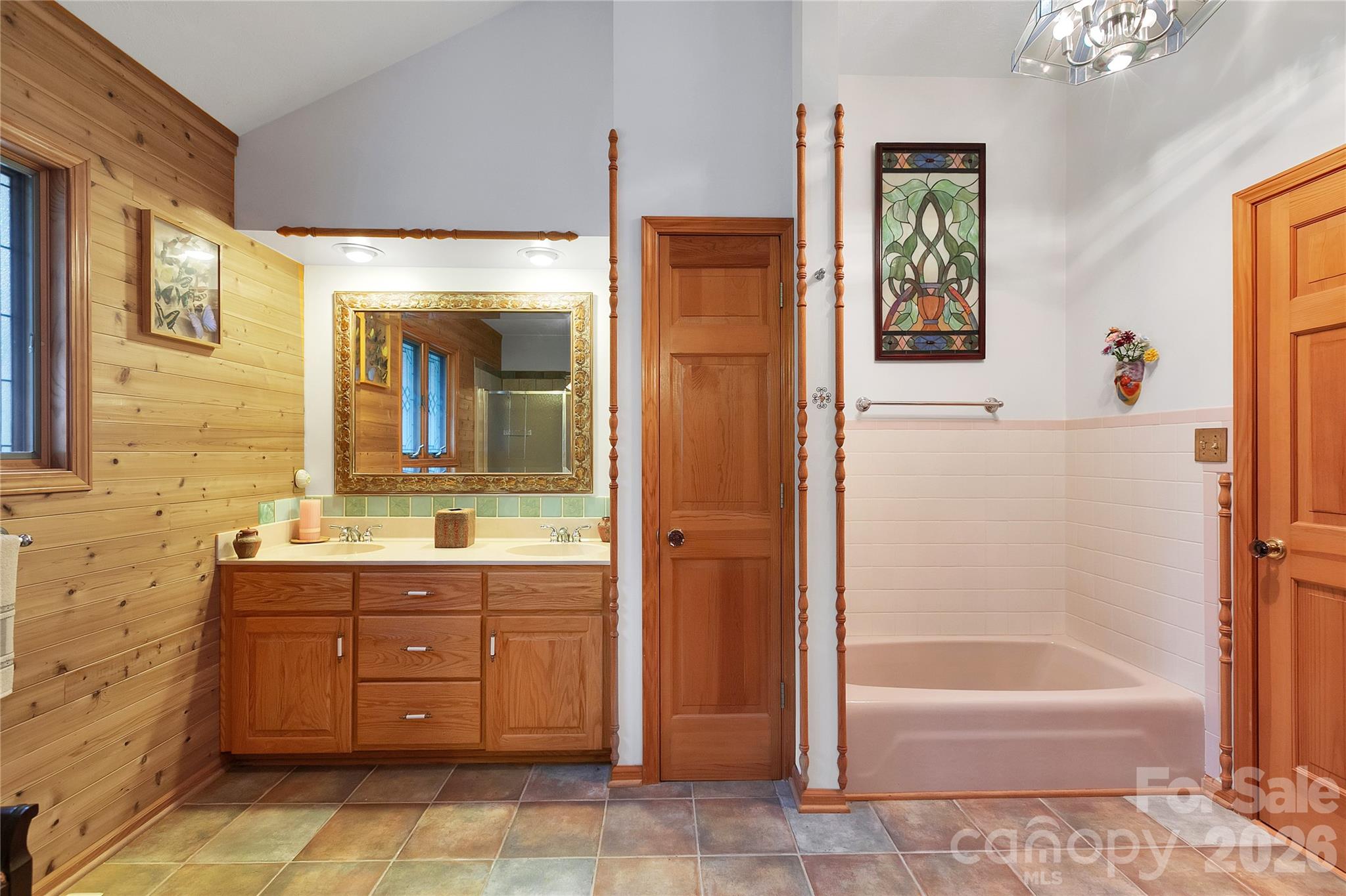 Just off of the primary bedroom is the laundry room and the primary bathroom, separate rooms! Double sink vanity, linen closet and low sided garden tub. - 275 Hubbard Hollow Road, Rosman