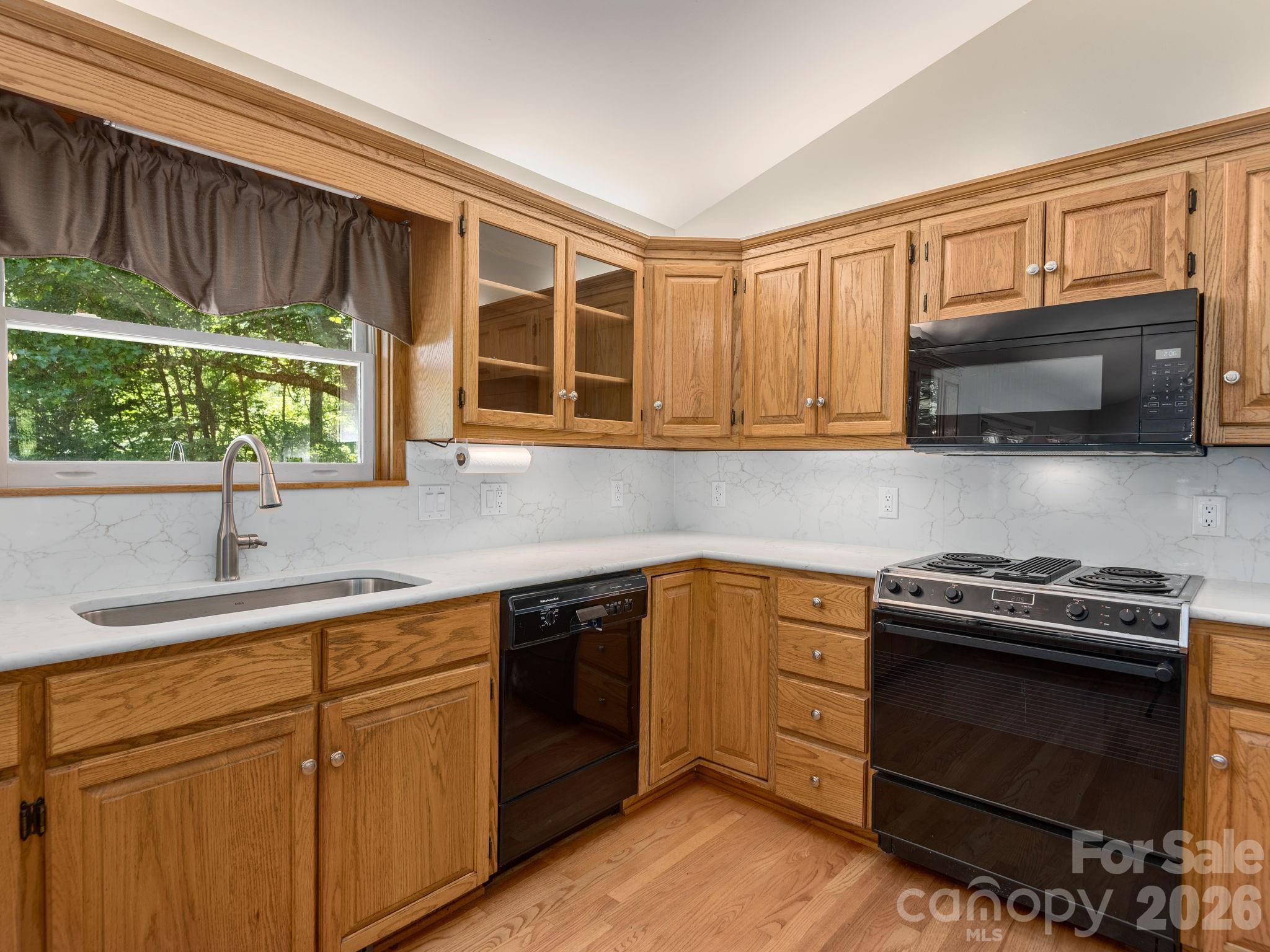 Updated backsplash beautifully complements the quality wood cabinetry. - 1572 Brushy Fork Road, Sylva
