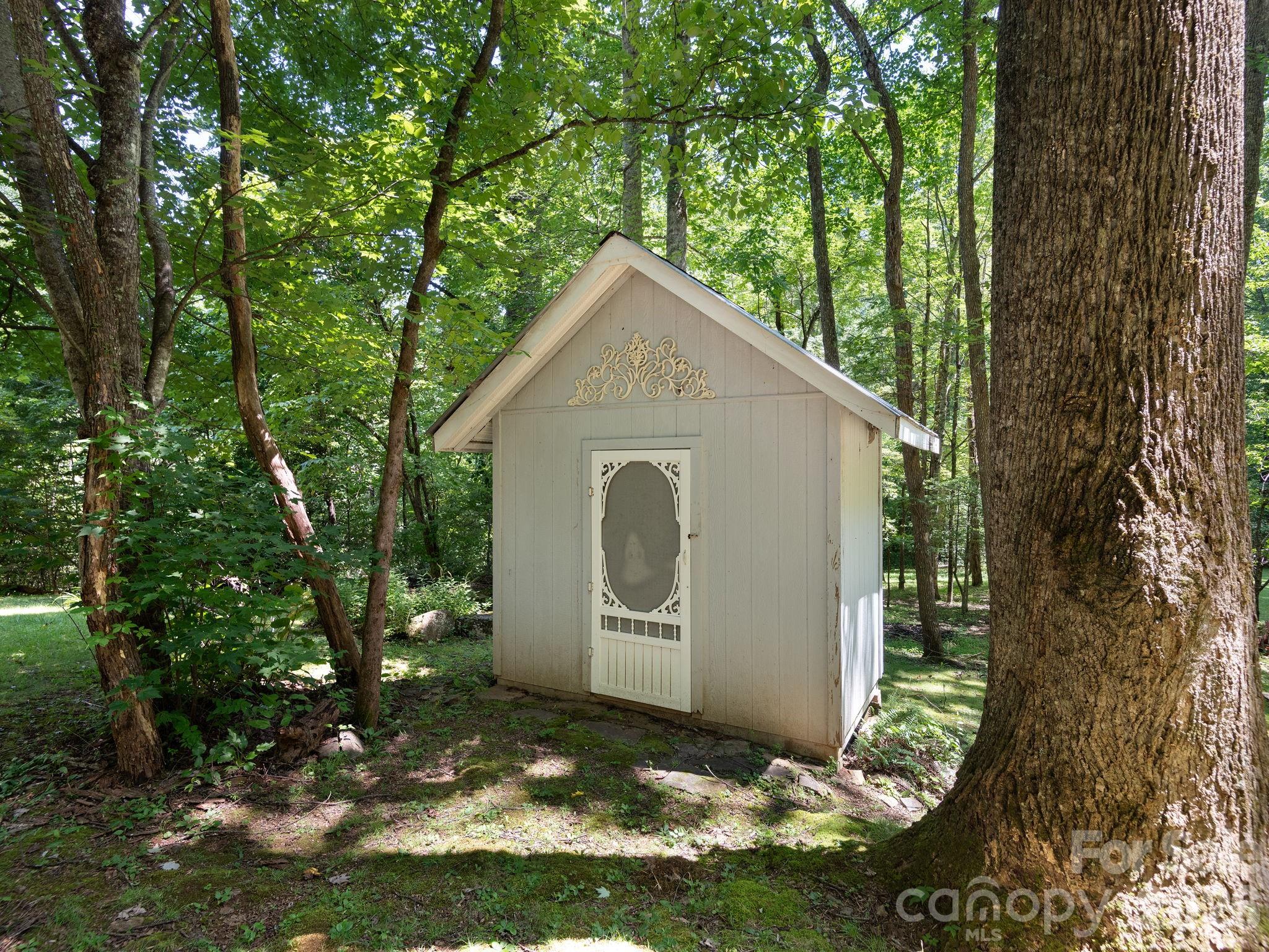A magical garden shed tucked among the landscape, where the owners have lovingly cultivated beautiful gardens, native plants, and botanical treasures that make this property truly special. - 1572 Brushy Fork Road, Sylva