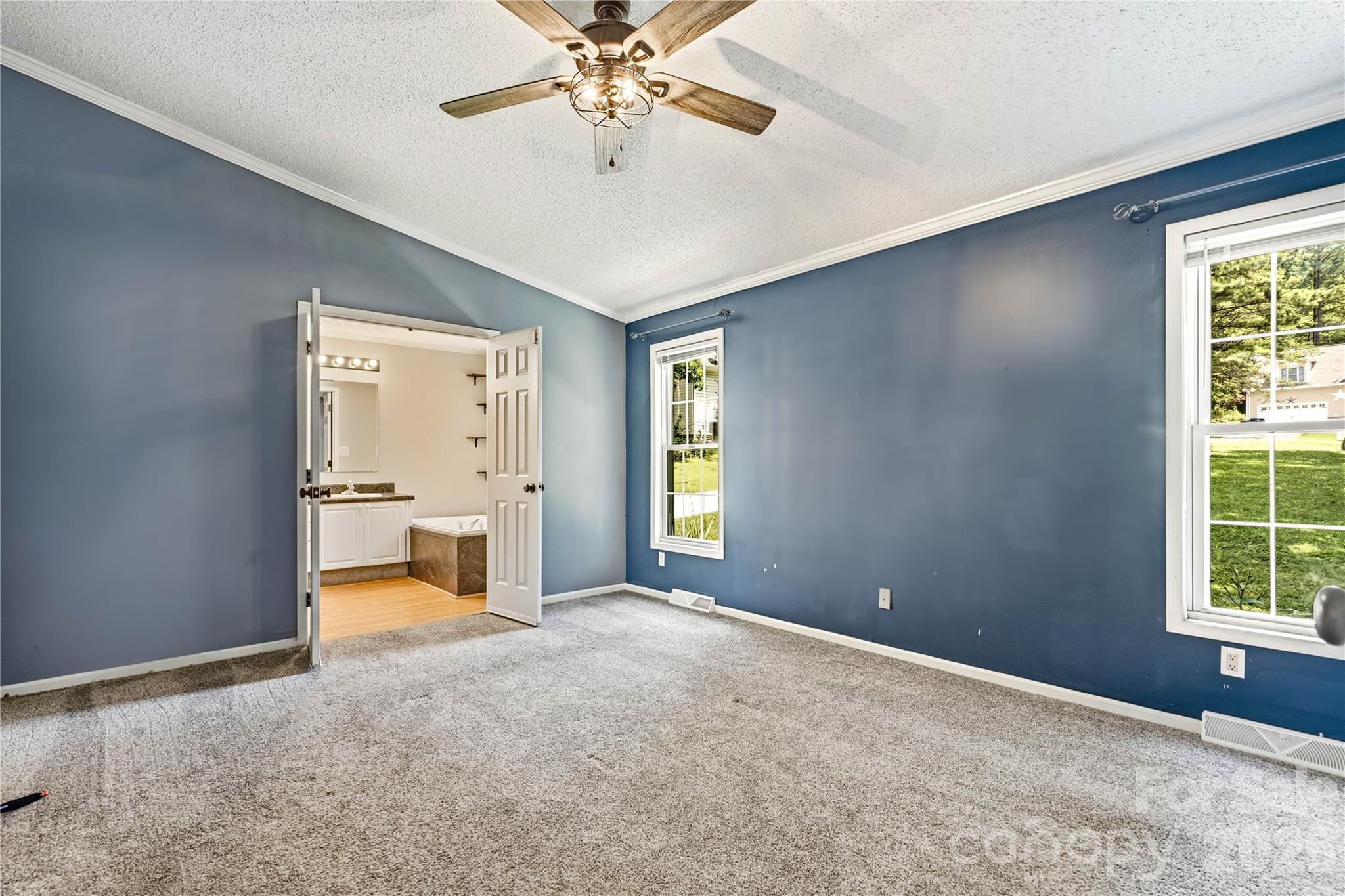Primary bedroom with double door entry to bathroom - 3555 Lake Bluff Drive, Sherrills Ford