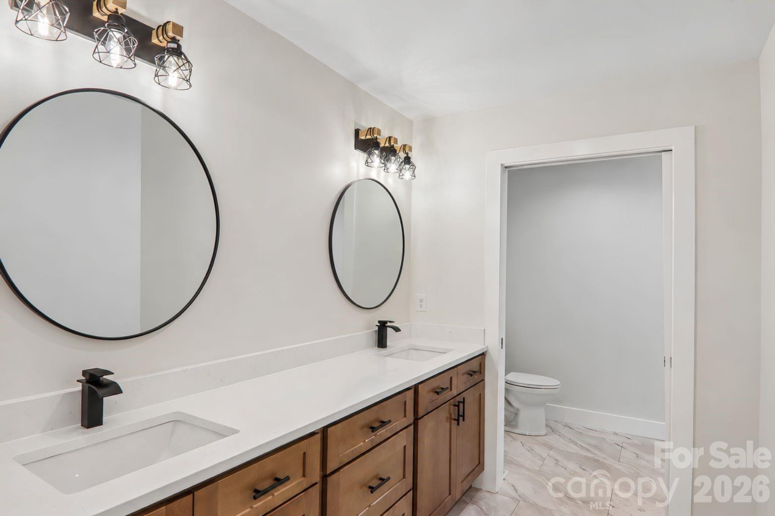 Hall bathroom with double vanities with pocket door privacy into the shower. - 140 N Main Street, Mars Hill