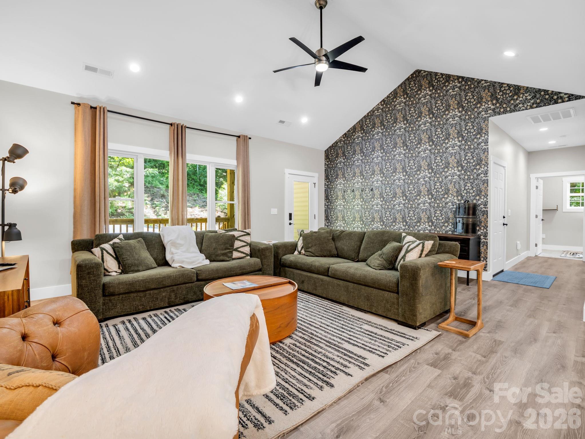 View from the dining area towards the front door. The hallway on the right leads to the garage, laundry room and primary ensuite bedroom. - 180 Ridgeview Drive, Hendersonville