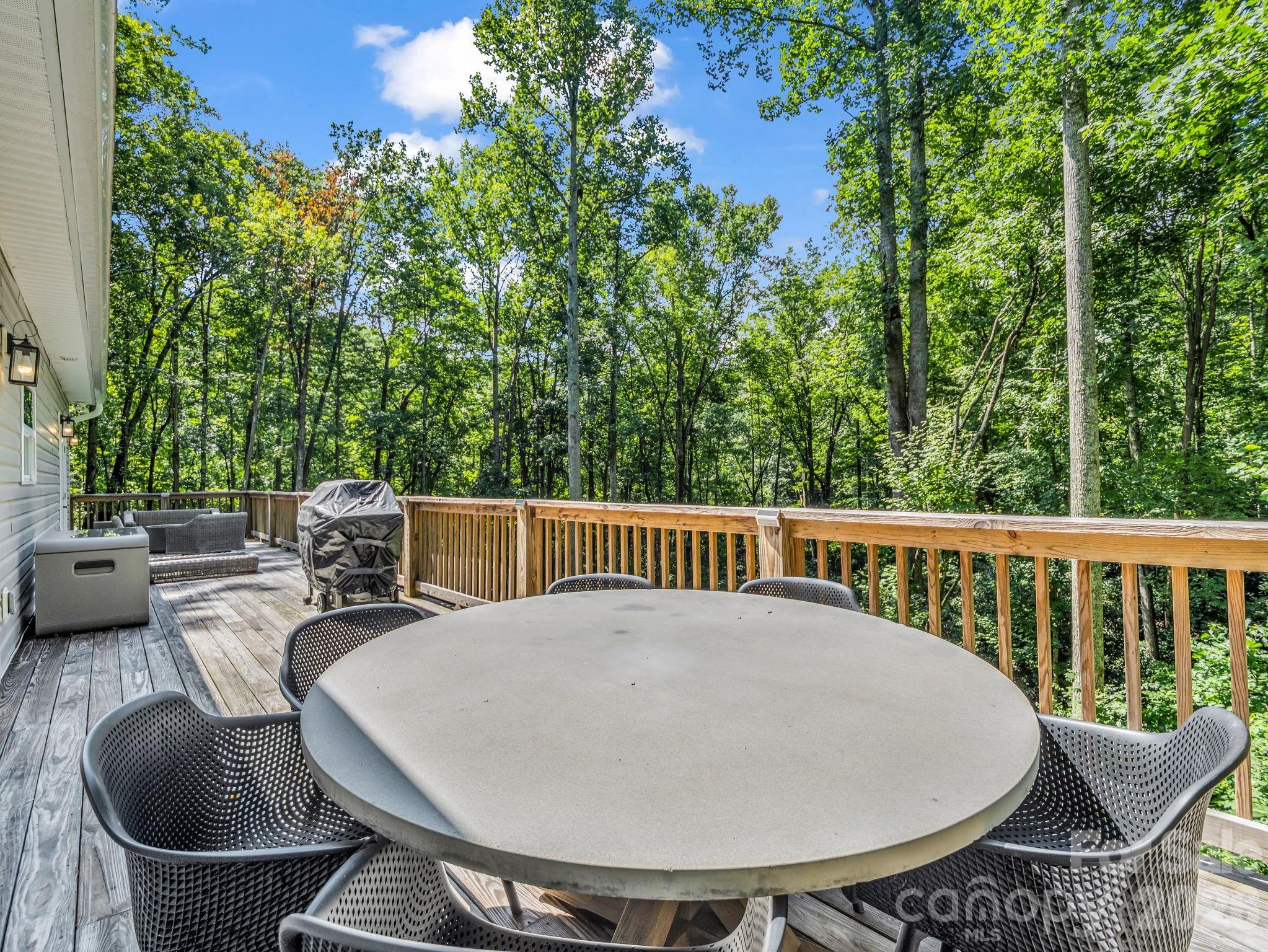 Large back deck with table, chairs, and propane gas fire pit. All available for purchase. - 180 Ridgeview Drive, Hendersonville