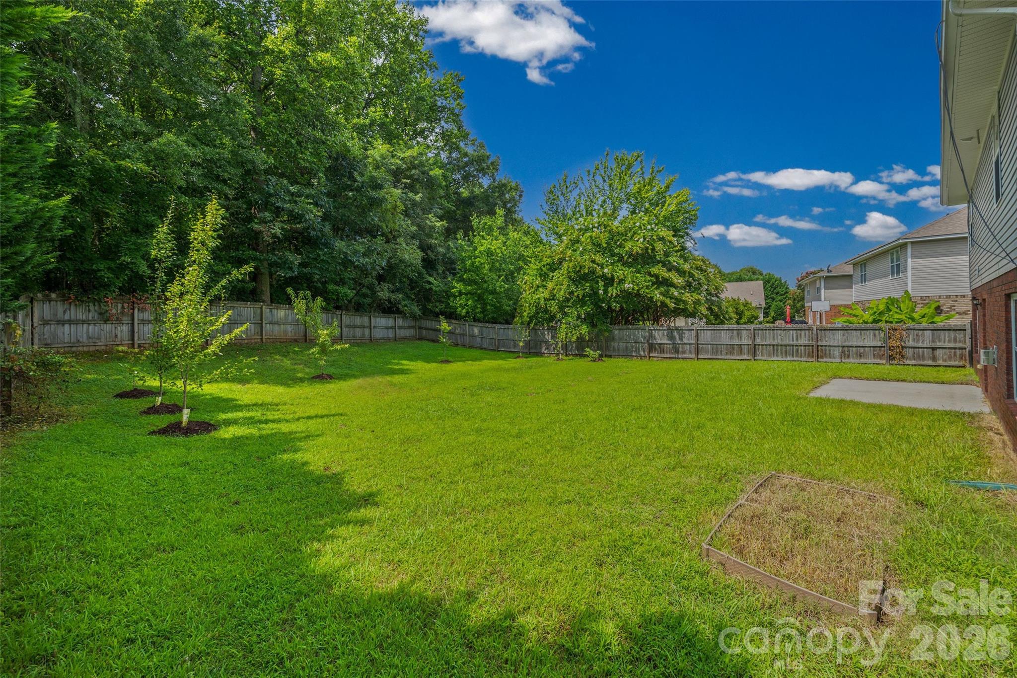 Enjoy the fenced backyard with fig, peach, Bartlett pear, apple, cherry blossom, and dogwood trees, along with room to relax, garden, or play. - 848 Estuary Court, Rock Hill