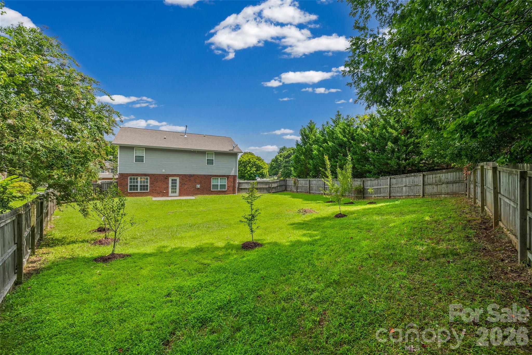 Enjoy the fenced backyard with fig, peach, Bartlett pear, apple, cherry blossom, and dogwood trees, along with room to relax, garden, or play. - 848 Estuary Court, Rock Hill