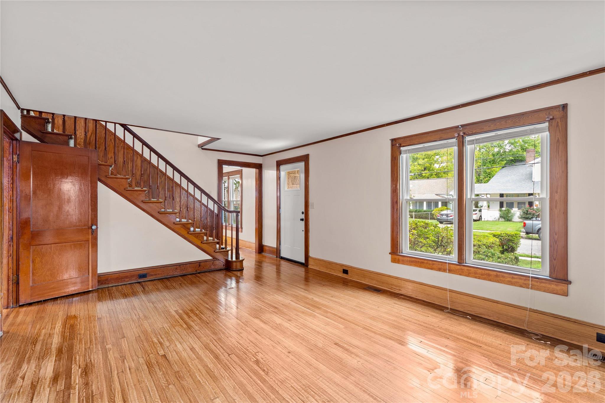 Living room has hardwood floors, original staircase and view of the the front. - 615 S Church Street, Salisbury