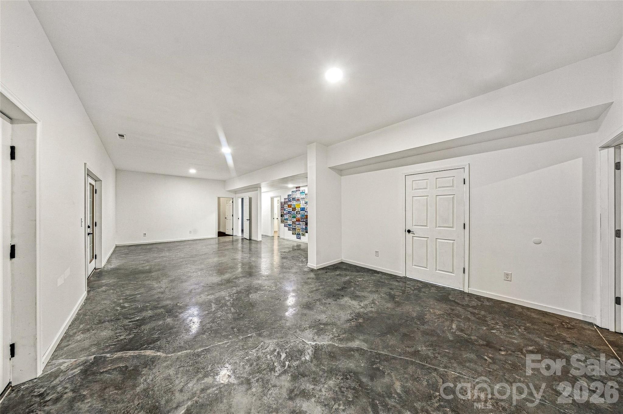 Clean Palate - concrete floors - double doors walk out. Waiting for your design! Plenty of storage. Fitness room and Spa room on this level. - 90 Ashley Woods Drive, Arden