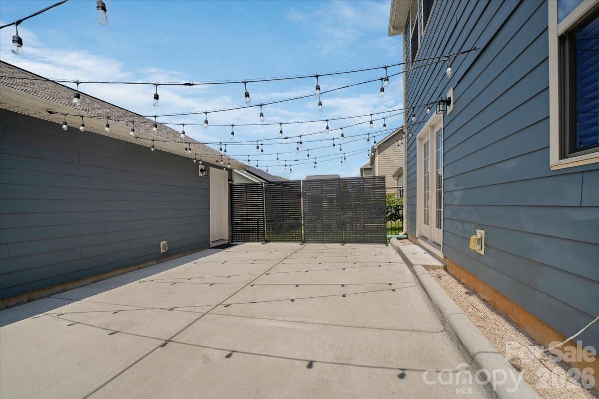 Low maintenance back patio with privacy panels and string lights. - 15505 Davidson East Drive, Davidson