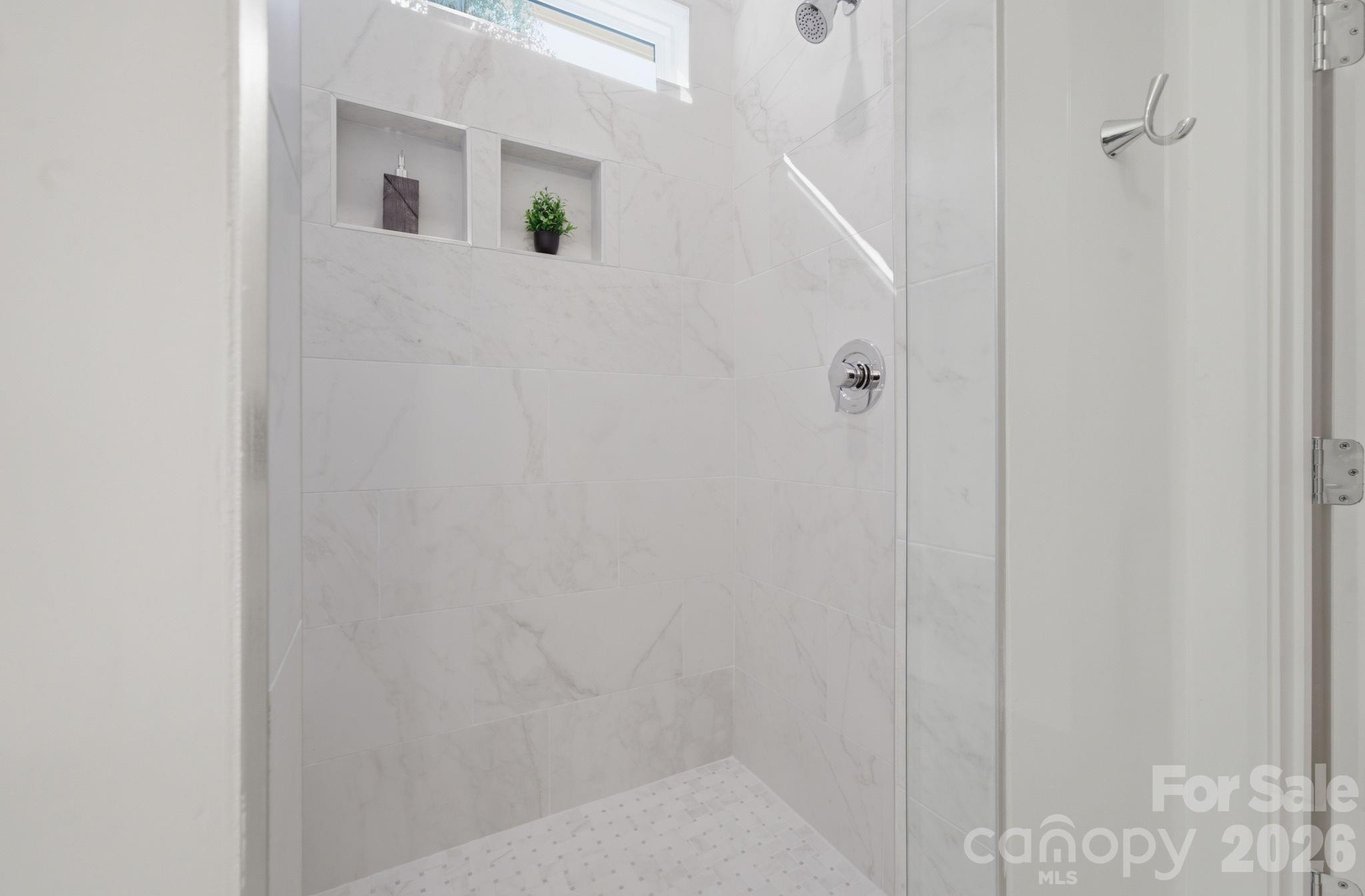 Luxurious primary bathroom with cohesive velvet white tile throughout - 612 Camelot Drive, Salisbury