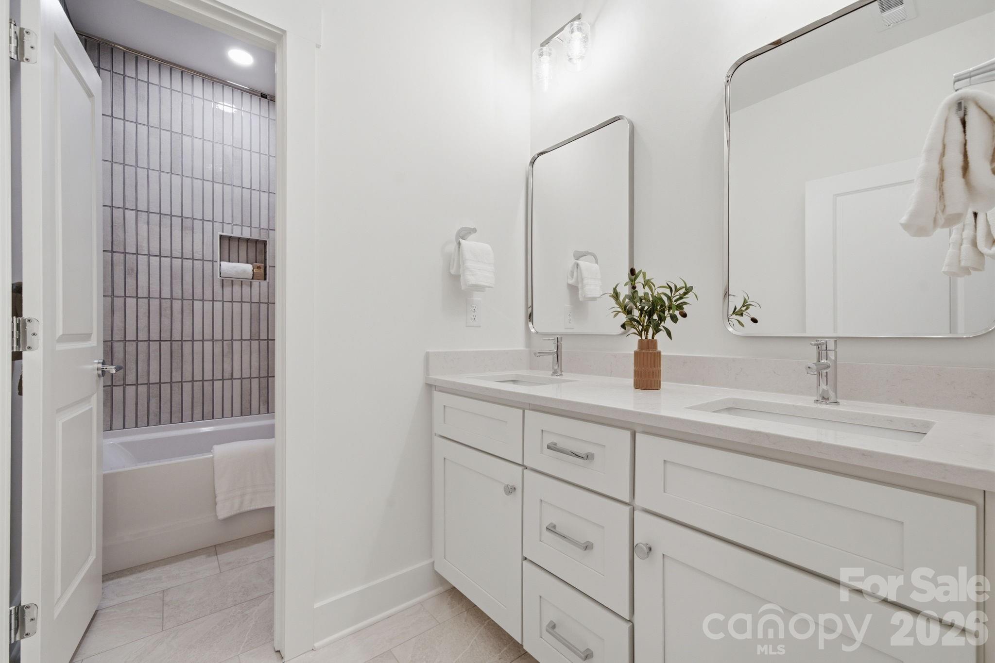Upstairs Full Bath 1 of 2 featuring gorgeous marmi calacatta tile floors and gaelic rain glossy shower tiles - 612 Camelot Drive, Salisbury