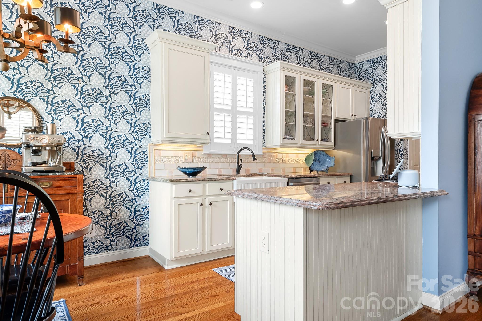 Looking from the rear of the home into the kitchen. Kitchen has been remodeled with new cabinets, designer tile backsplash, countertops, sink and gas range. Notice the Serena and Lily wallpaper. - 17525 Calverton Road, Huntersville