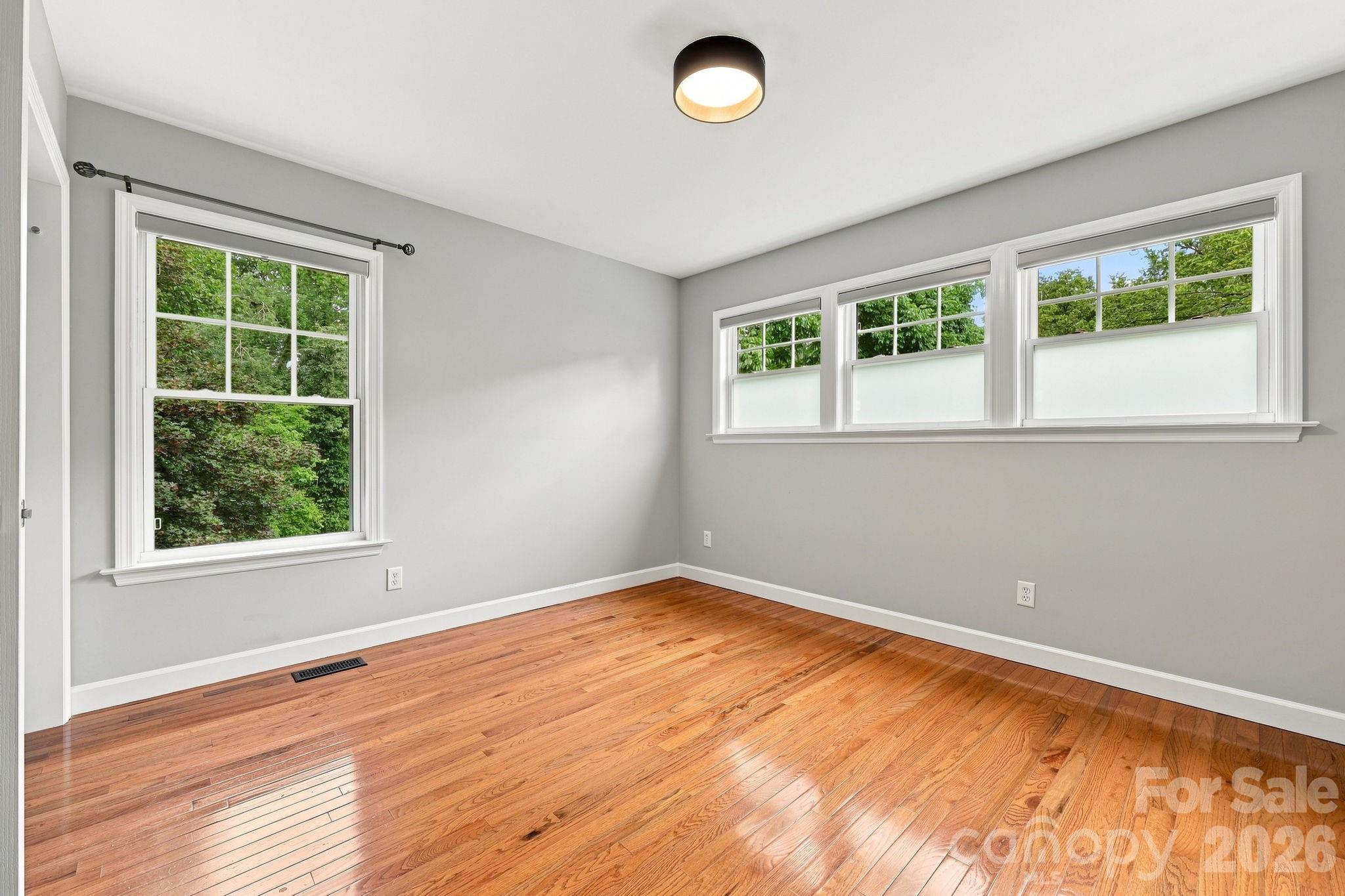 Primary bedroom featuring abundant natural light and custom window treatments. - 146 Courtland Avenue, Asheville
