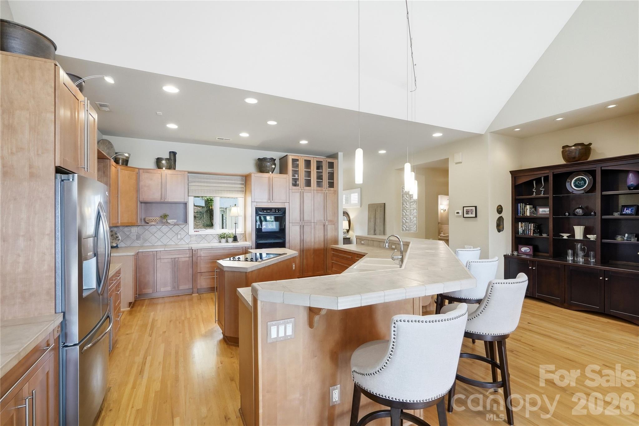Equipped with stainless steel appliances, a center island, and a breakfast bar - 1075 Lakefront Woods Drive, Belmont