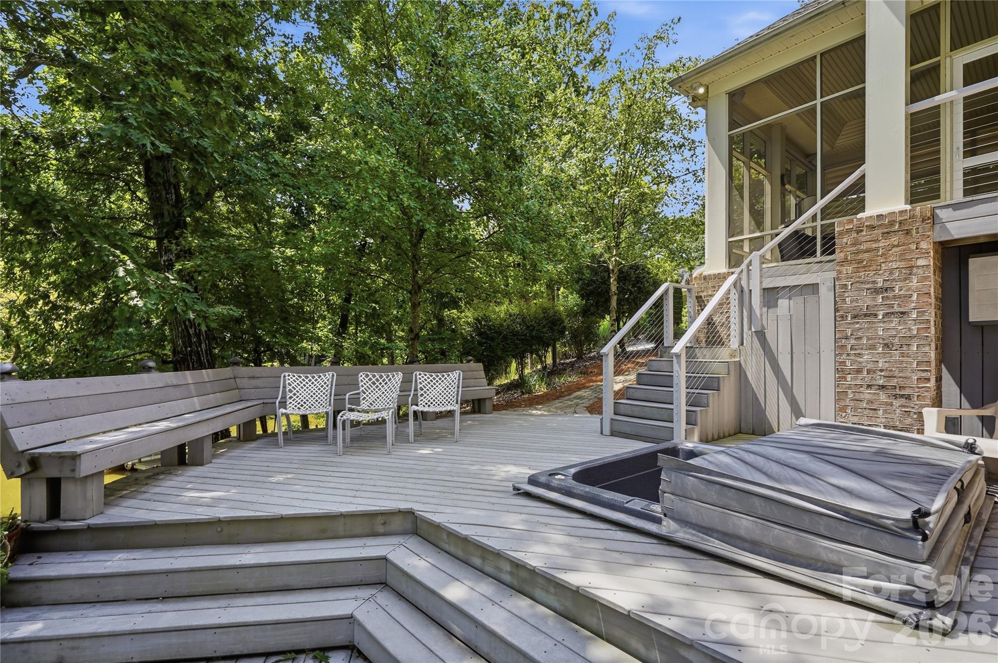 Enjoy lake views from the spacious Trex deck with hot tub, stone paver patio, or the cozy screened porch - 1075 Lakefront Woods Drive, Belmont