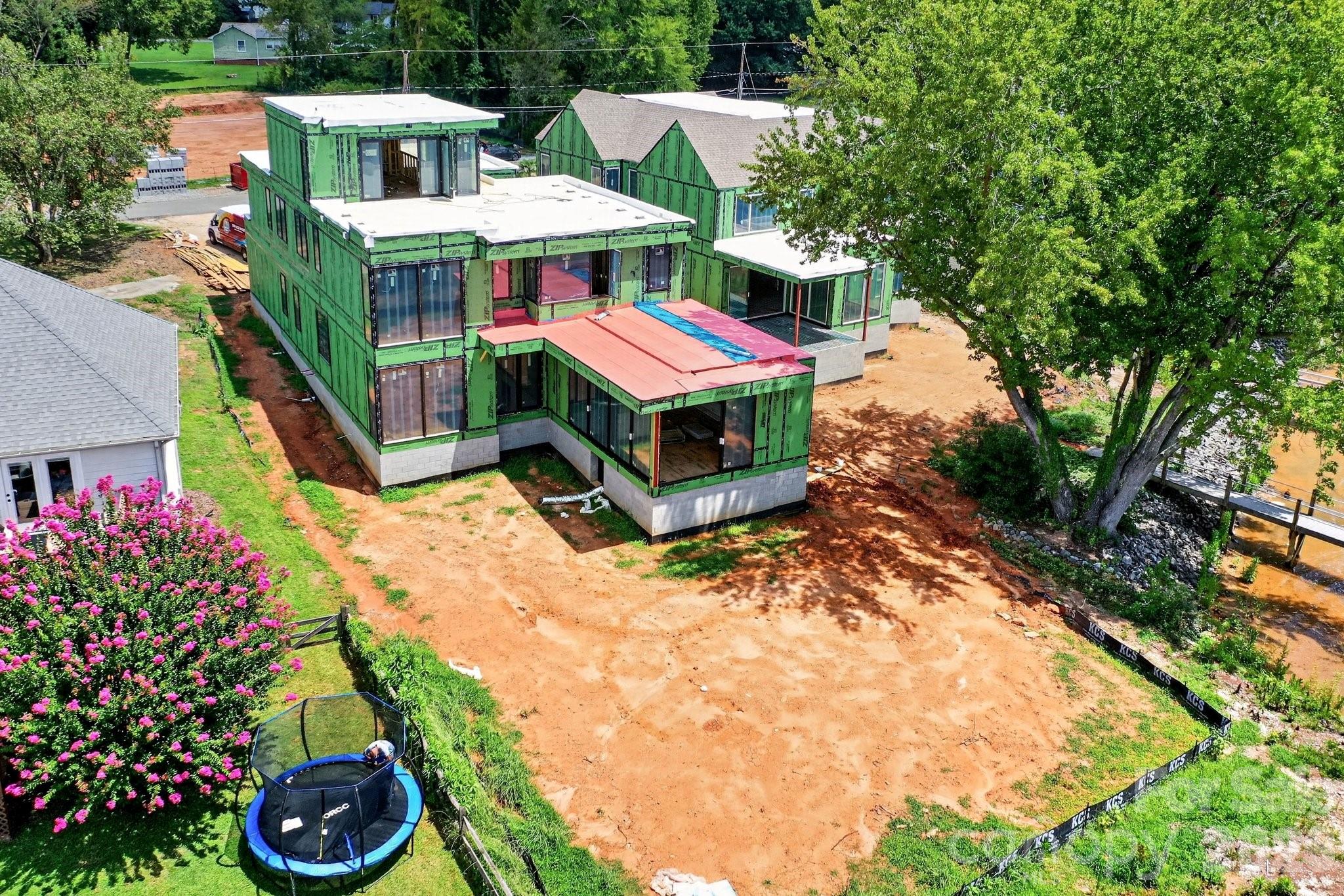 Real life construction process showing the home is under roof with windows and roofing completed in 8/2026. Has a fantastic backyard for a pool! - 21506 Rio Oro Drive, Cornelius