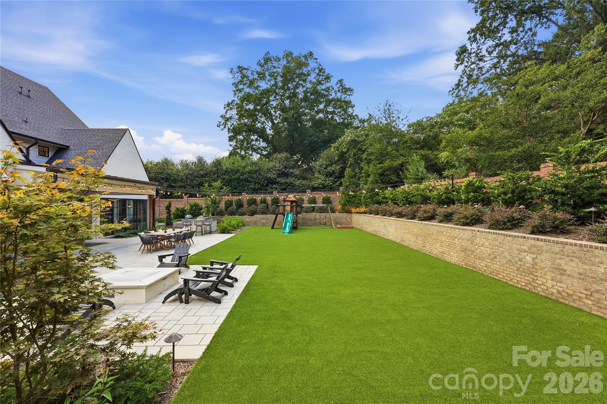 Large turf lawn with lots of mature plantings and brick privacy wall. - 2610 Sedley Road, Charlotte