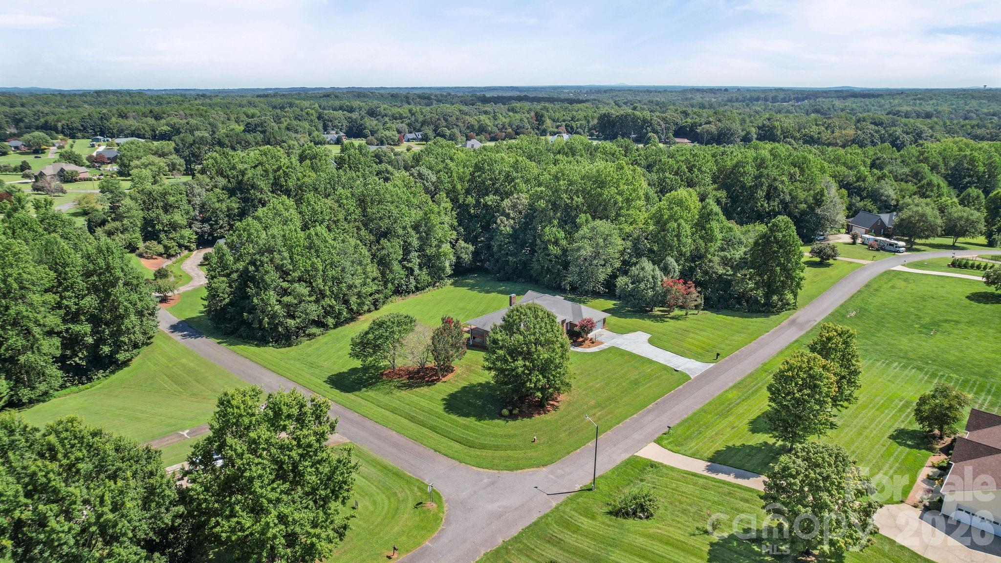 Beautiful corner lot with green space, a manicured lawn, and mature trees that provide ample privacy. - 3008 Eaker Drive, Cherryville