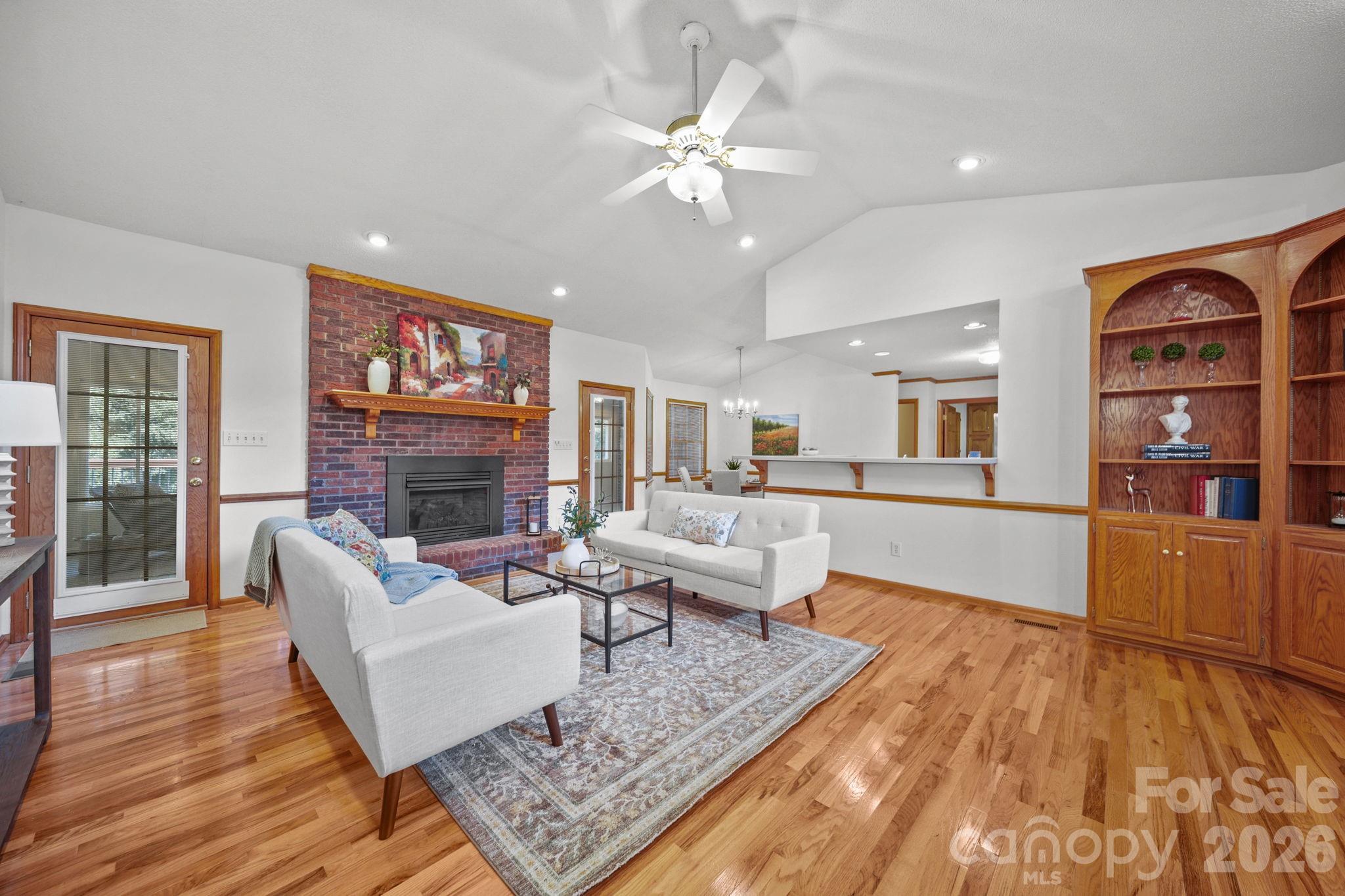 Vaulted ceilings, custom built-ins, a brick fireplace with gas logs, a wood mantle, and French doors leading to a 4-season sunroom make up the family room. - 3008 Eaker Drive, Cherryville