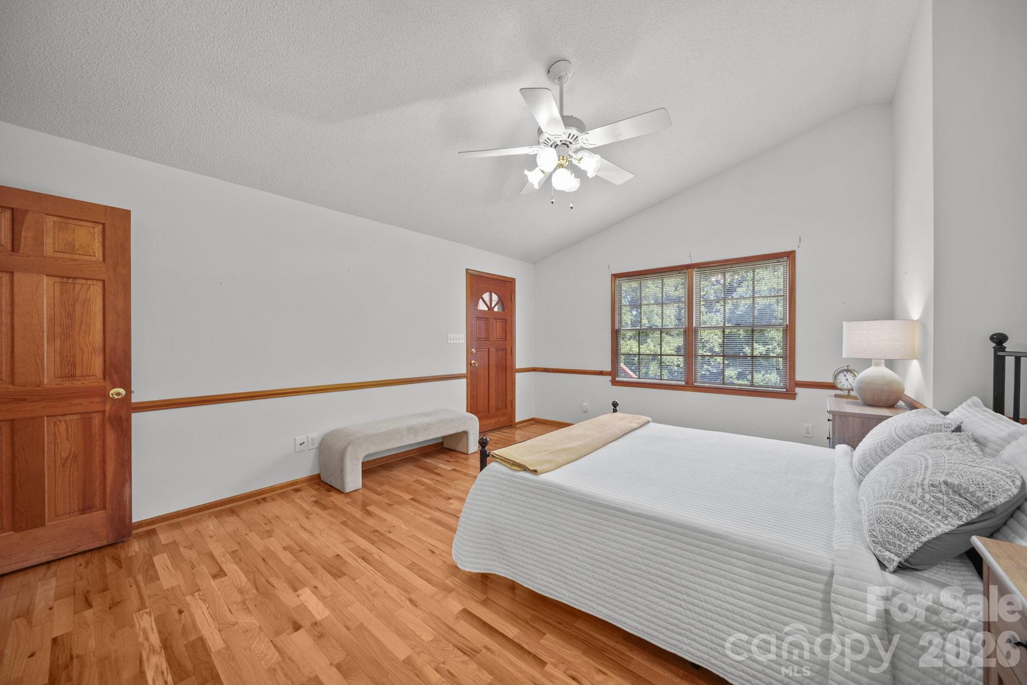 The primary bedroom has a vaulted ceiling, two windows overlooking the private backyard, and a door leading to the four-season sunroom. - 3008 Eaker Drive, Cherryville