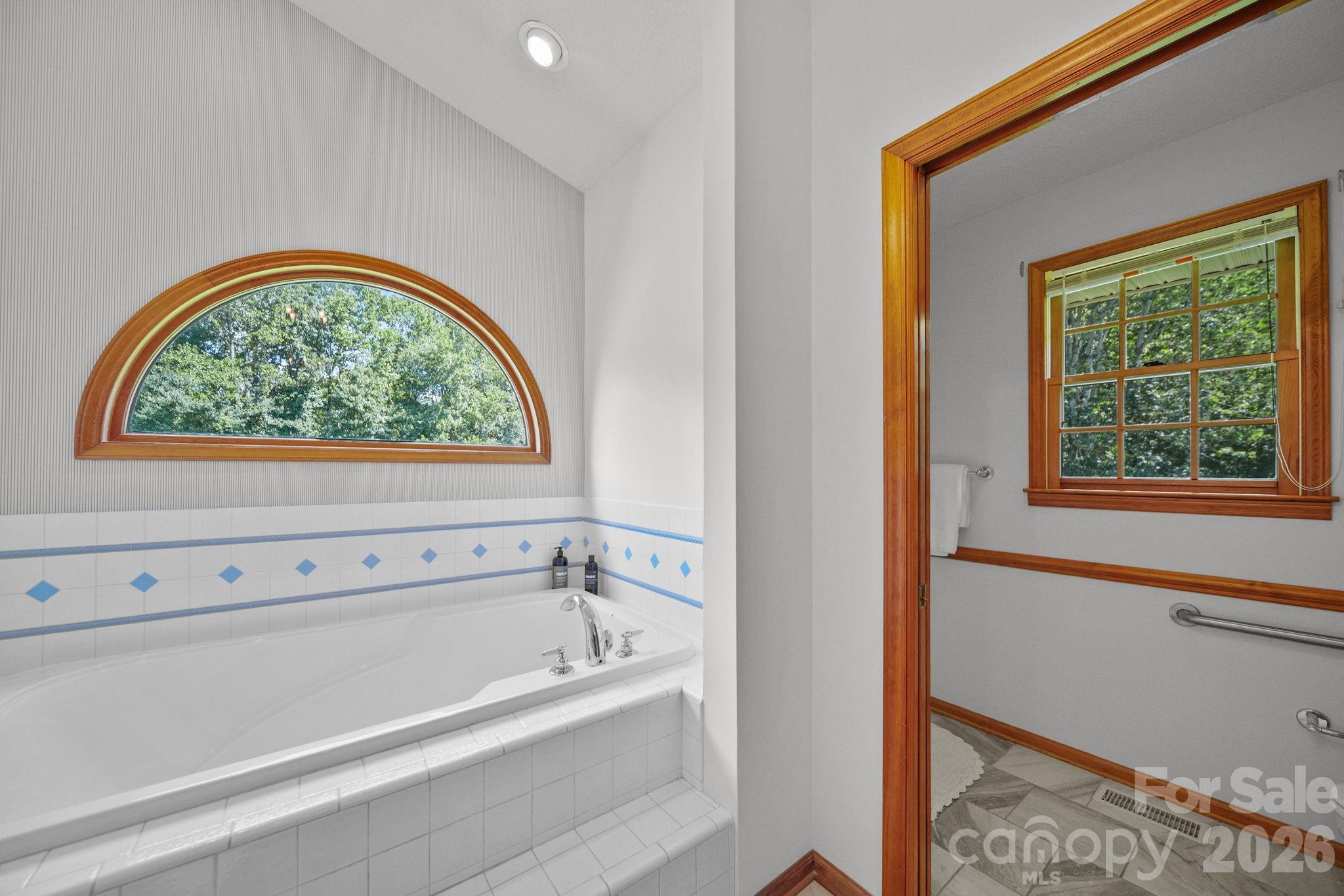 Oversized tub, tiled shower, and water closet with a pocket door. - 3008 Eaker Drive, Cherryville