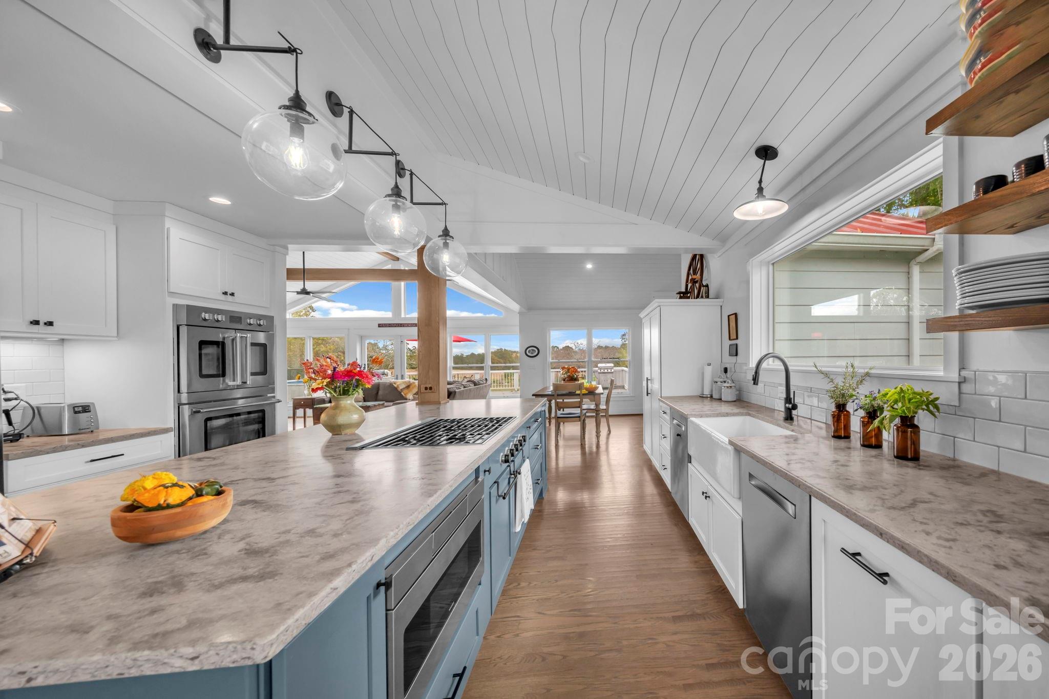 Honed quartz countertop, tile backsplash, farmhouse porcelain sink, & glass globe pendant light fixtures - 1260 Beaver Island Trail Road, Walnut Cove
