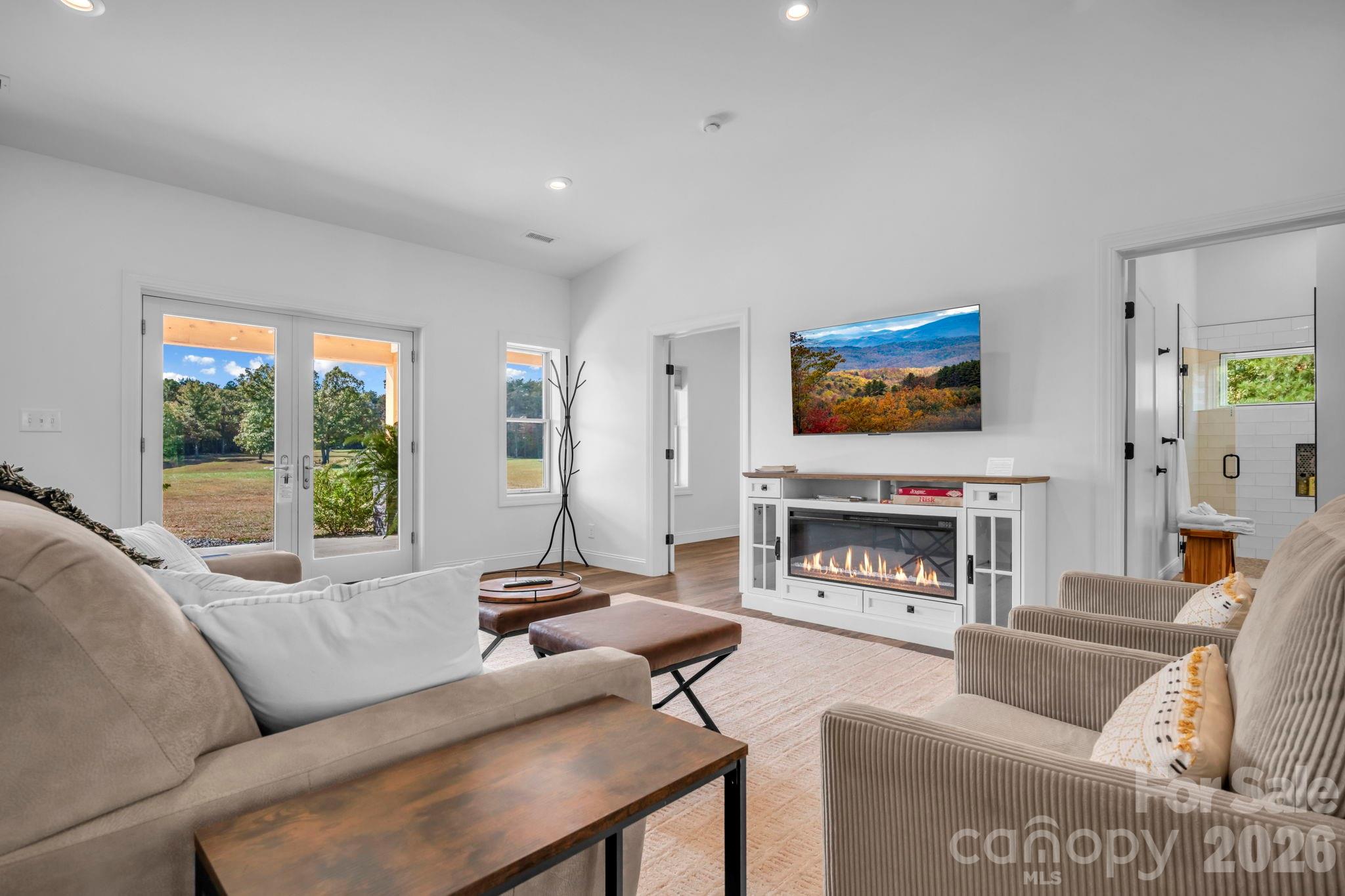 Living room w/ built in electric fireplace cabinet, LVP flooring throughout, and cathedral ceilings - 1260 Beaver Island Trail Road, Walnut Cove