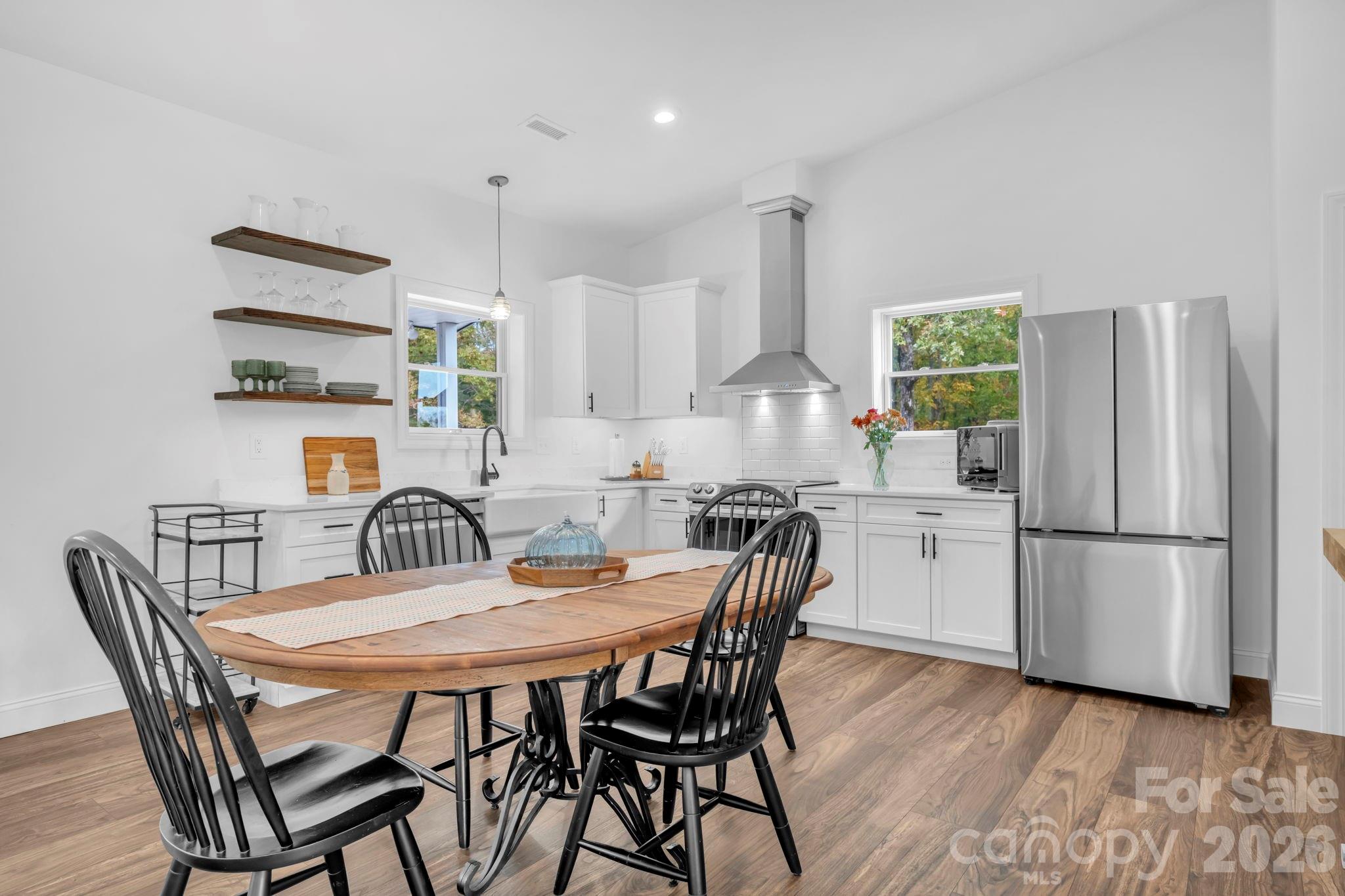 Guest house kitchen w/ Samsung appliances, 3 decorative floating shelves, and open floor plan to living room - 1260 Beaver Island Trail Road, Walnut Cove