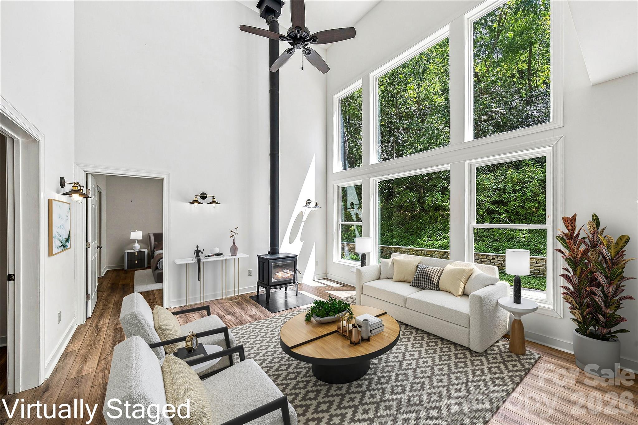 Dramatic great room with wall of windows and wood stove - 820 Merrills Cove Road, Asheville