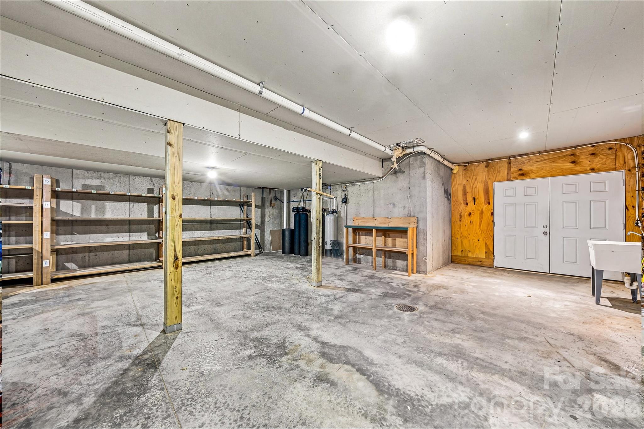 Expansive unfinished walk-out basement w/ preventative water filtration system - 820 Merrills Cove Road, Asheville