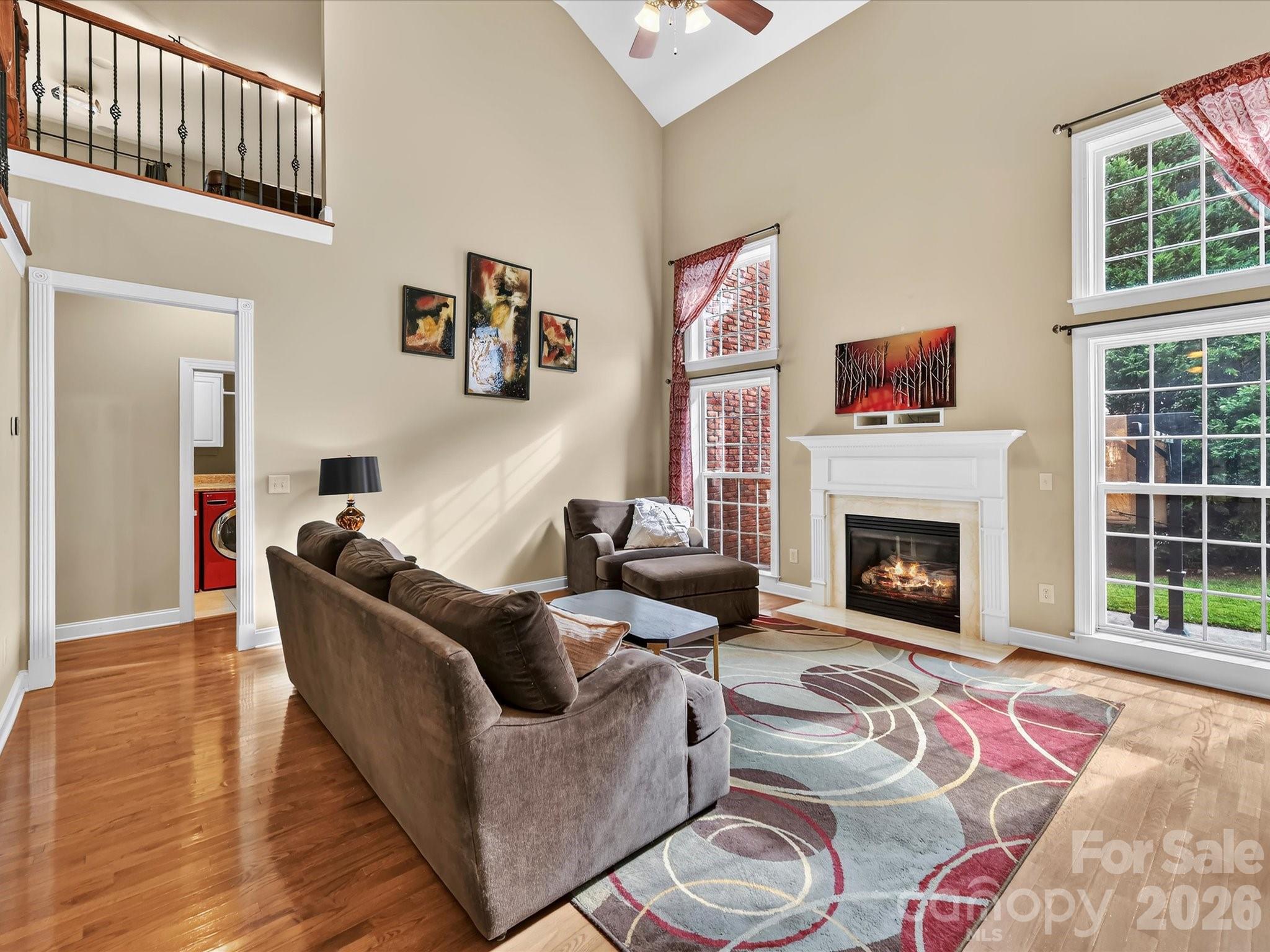 Soaring ceilings, expansive windows, and an open staircase create a bright and impressive two-story living space. - 11203 Warfield Avenue, Huntersville