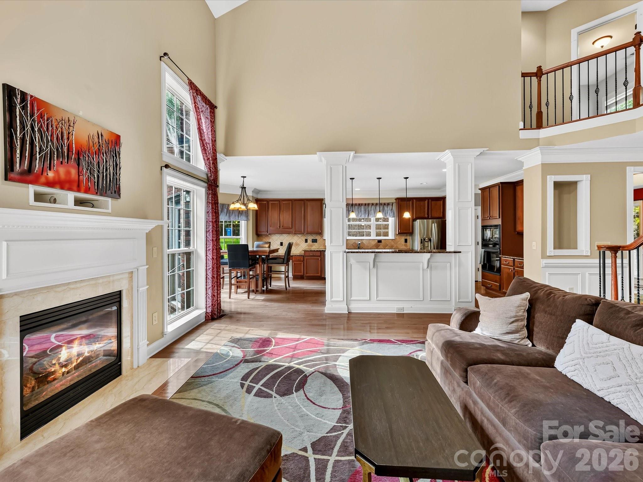 Soaring ceilings, expansive windows, and an open staircase create a bright and impressive two-story living space. - 11203 Warfield Avenue, Huntersville