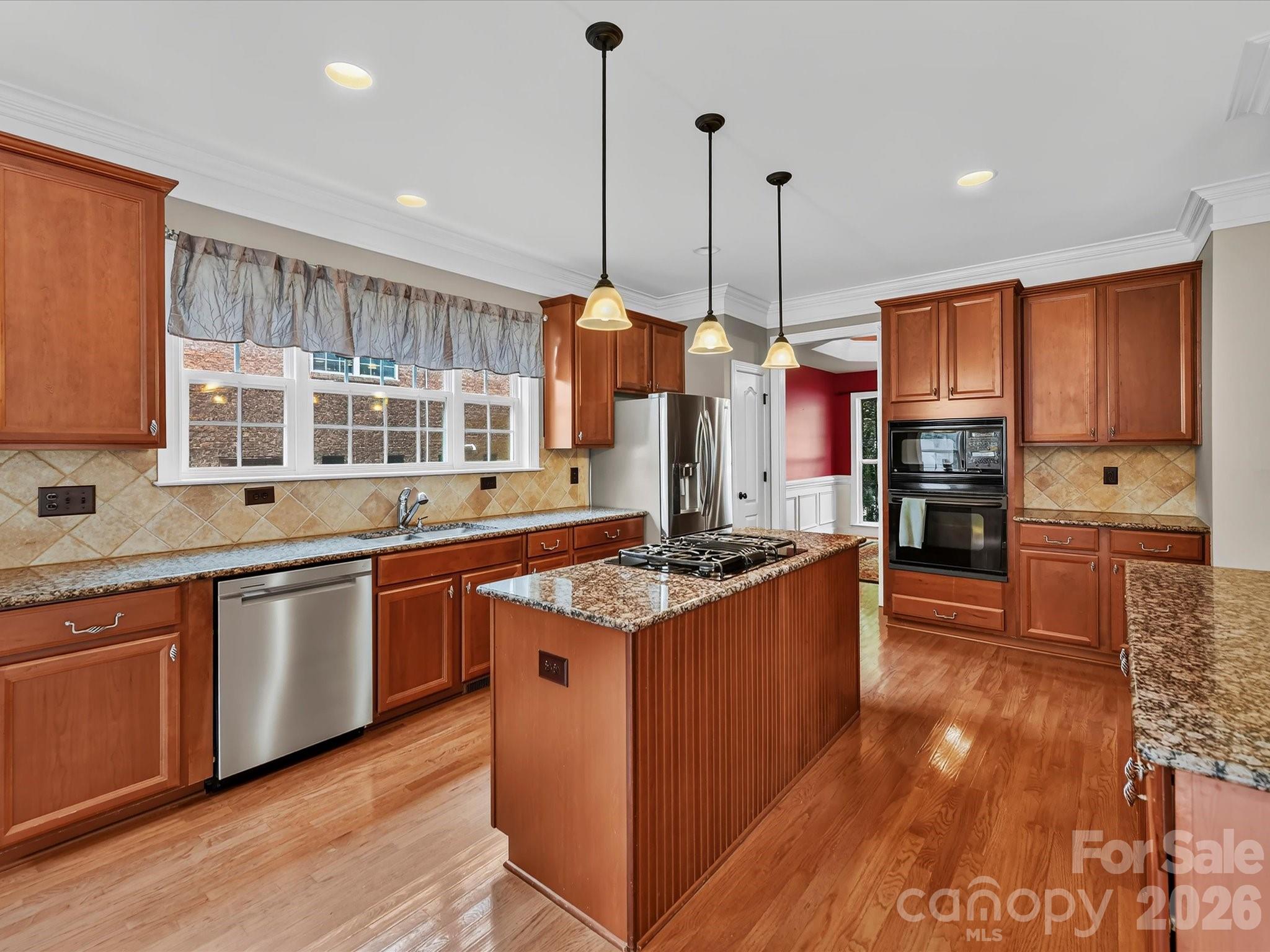 Spacious kitchen featuring granite countertops, stainless steel appliances, abundant cabinetry, and a large center island with gas cooktop. - 11203 Warfield Avenue, Huntersville