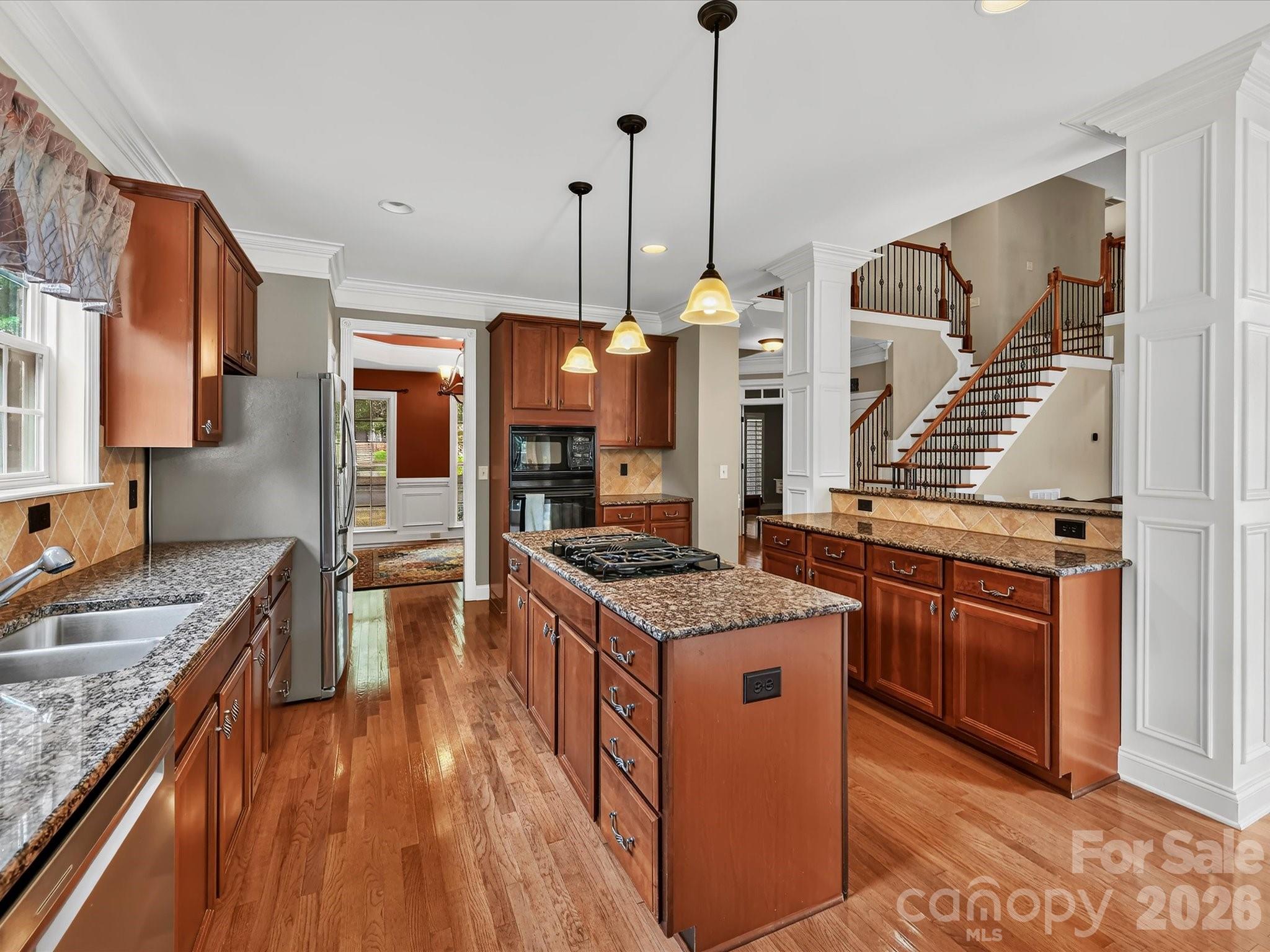 Spacious kitchen featuring granite countertops, stainless steel appliances, abundant cabinetry, and a large center island with gas cooktop. - 11203 Warfield Avenue, Huntersville